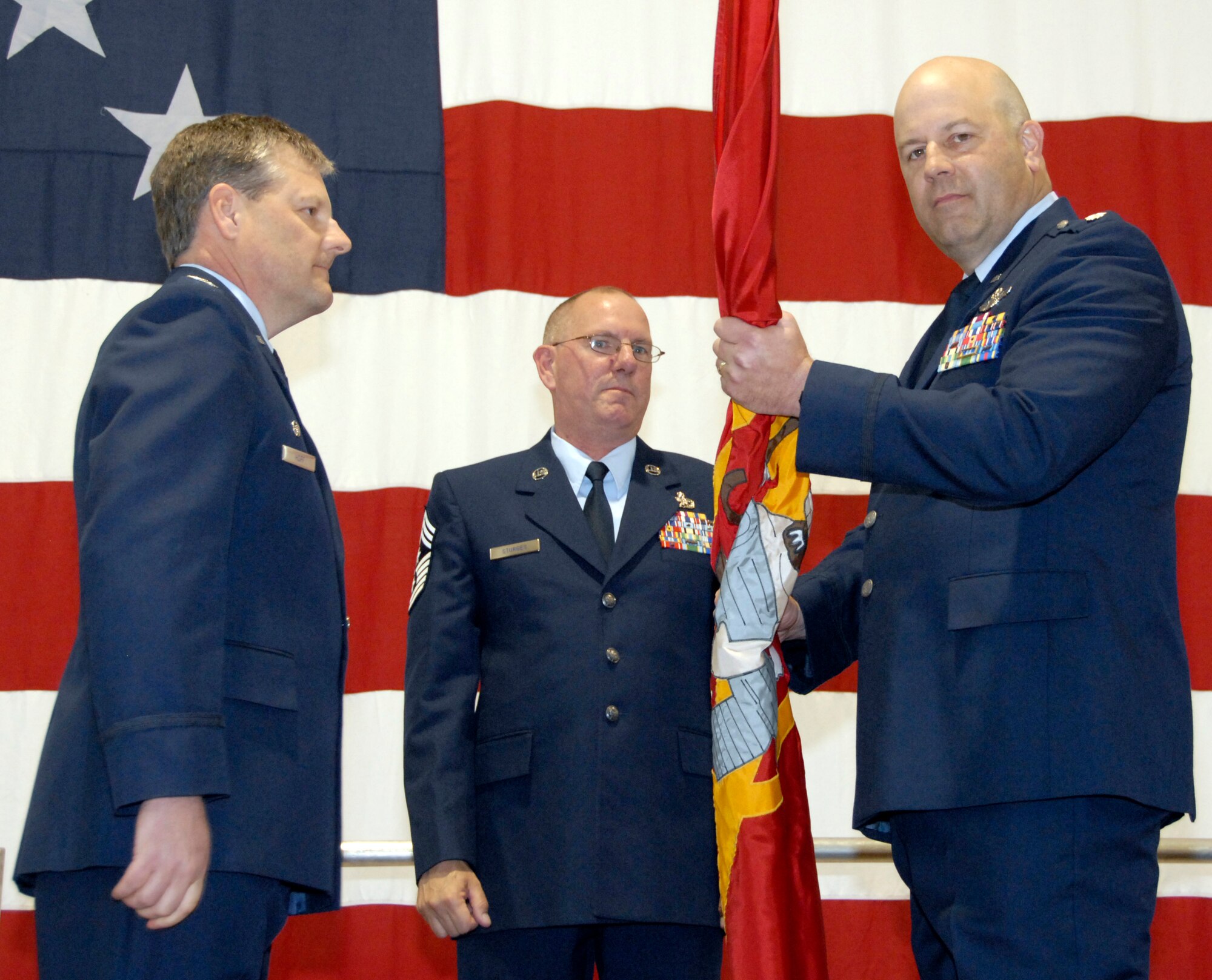 Lt. Col. Brian Borgen, right, takes command of the 303rd Fighter Squadron during a ceremony in the 442nd Fighter Wing's 5-bay Hangar April 4, 2009.  The 303rd FS is an Air Force Reserve flying squadron, operating 27 A-10 Thunderbolt II aircraft.  Officiating the change-of-command ceremony was Col. John Hoff, 442nd Operations Group commander (left), and the 442nd Command Chief Master Sgt., Chief Al Sturges.  The squadron is part of the 442nd Fighter Wing, based at Whiteman Air Force Base, Mo. The squadron has deployed aircraft and pilots four times to Iraq and Afghanistan to provide close air support, combat search and rescue, and forward-air control capabilities for the Global War Against Terror.  Colonel Borgen replaced Lt. Col. Mark Ernewein as the 303rd Fighter Squadron's commander.  (U.S. Air Force photo/Maj. David Kurle)