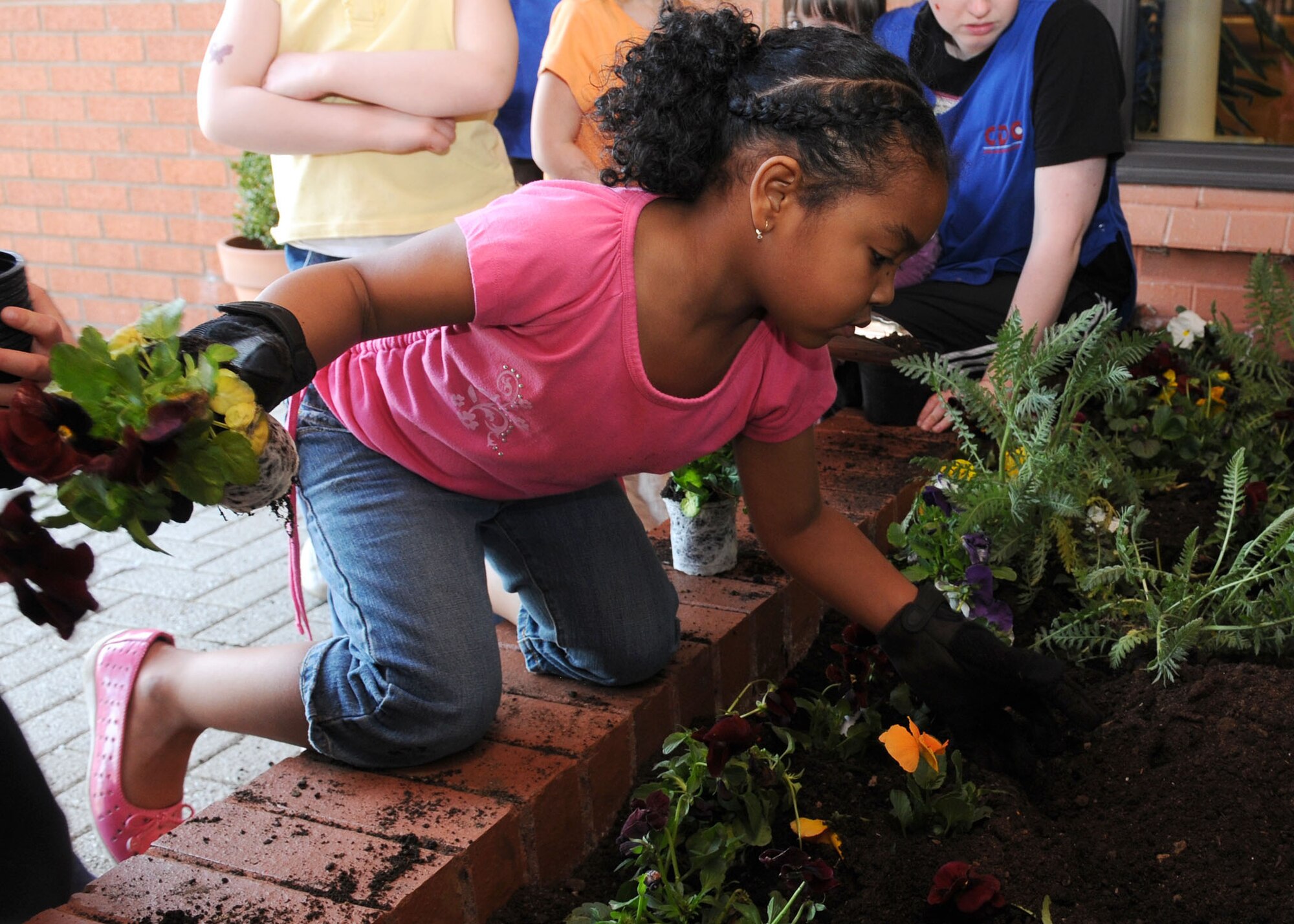 Five-year old Aja Robinson, daughter of Tech. Sgt. Jantani Robinson from the 488th Intelligence Squadron, plants a flower in the Child Development Center garden during Earth Day April 22, 2009, at RAF Mildenhall, England. Earth Day is designed to inspire awareness, appreciation and importance to care for earth’s environment. (U.S. Air Force photo by Staff Sgt. Jerry Fleshman)