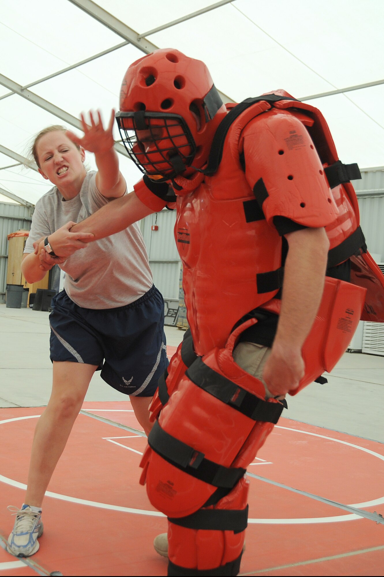 Capt. Jennifer Pearson, 380th Air Expeditionary Wing, Public Affairs Officer, gives a blow to the head of Mr. Rick Baldwin, a Northrop Grumman contractor posed as the "red man attacker" during self-defense training, April 18 at an undisclosed location in Southwest Asia. The Sexual Assault Response Coordinator (SARC) sponsored the training that gave students the chance to learn techniques to defend themselves from attack. Captain Pearson is deployed from Langley AFB, Va. and hails from Hampton, Va. (U.S. Air Force photo by Senior Airman Brian J. Ellis) (Released)