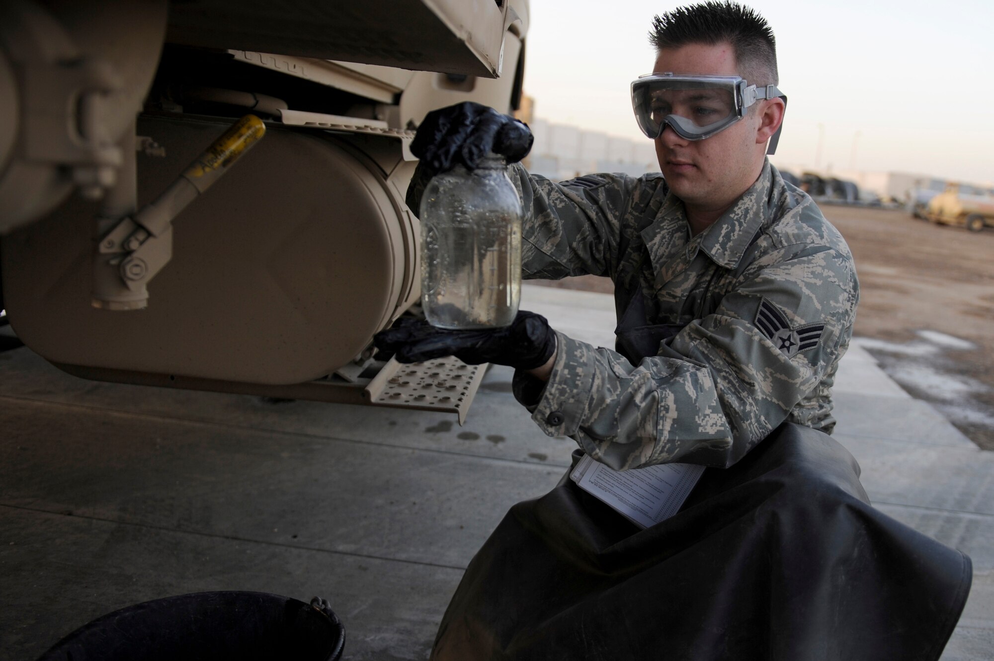 Senior Airman Brian Amos, 380th Expeditionary Logistics Readiness Squadron, fuels flight, performs a visual analysis on a quart sample of fuel taken from an R-11 fuel truck during a fuel checkpoint operation, April 4 at an undisclosed location in Southwest Asia. Airman Amos is deployed from Nellis AFB, Nev. and hails from Las Vegas, Nev. (U.S. Air Force photo by Senior Airman Brian J. Ellis) (Released)