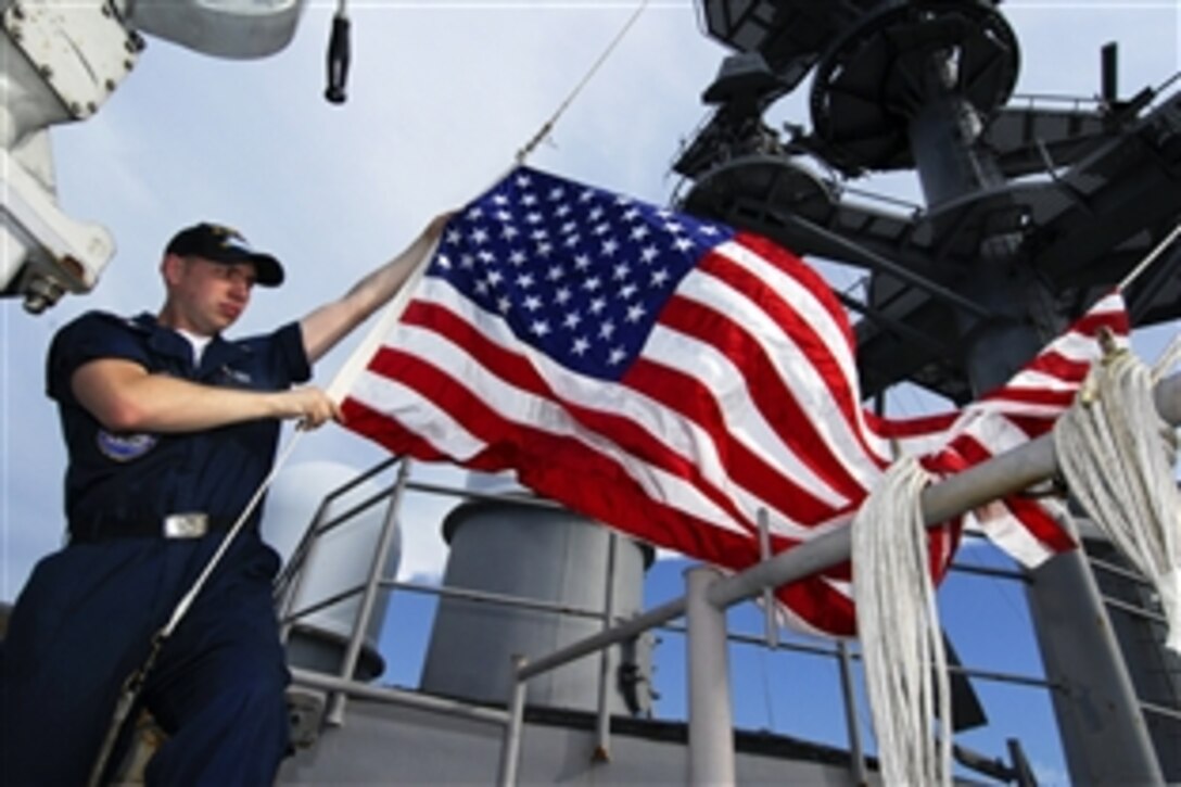 U.S. Navy Petty Officer 3rd Class Jason Schultz raises the national ensign on the signal bridge aboard the aircraft carrier USS John C. Stennis in the Pacific Ocean, April 21, 2009. John C. Stennis is on a scheduled six-month deployment to the western Pacific Ocean.