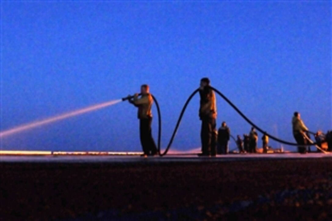 U.S. Navy sailors man fire hoses during a night scrub exercise on the flight deck of the aircraft carrier USS Ronald Reagan in the Pacific Ocean, April 18, 2009. Scrub exercises are commonly performed after sustained flight operations or before returning to home port. Ronald Reagan is underway performing Fleet Replacement Squadron Carrier Qualifications.