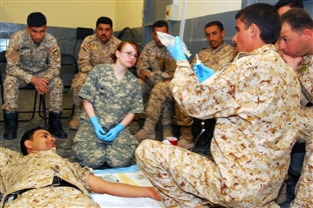U.S. Army Spc. Krystal Smith watches as an Iraqi police medic attaches the intravenous line to the fluid bag during the final testing day for a medic training course on Forward Operating Base Delta, Iraq, April 16, 2009. Smith is a course instructor and medic assigned to Company C, 589th
Brigade Support Battalion.