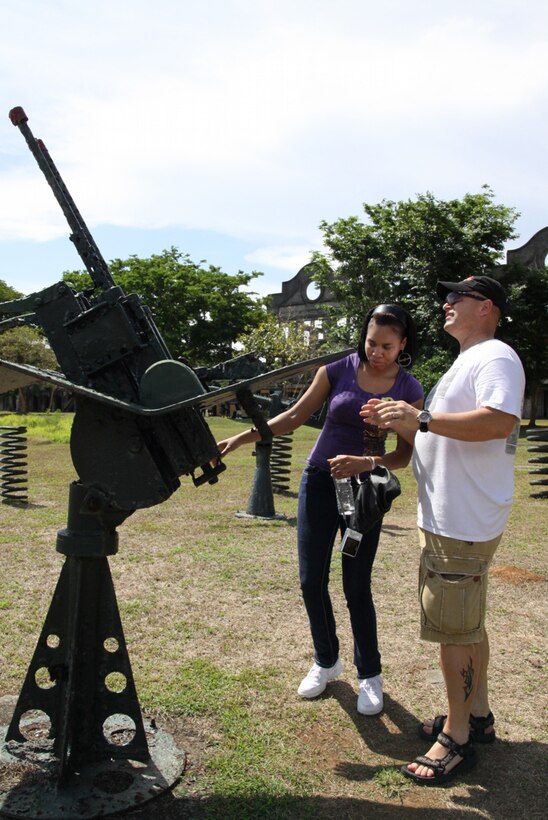 Gunnery Sgt. Bill Elver, postal operations staff noncommissioned officer, III MEF, explains parts of World War II-era weaponry to Lance Cpl. Tyrika Bradby, administration clerk, III MEF during a visit to the historical island of Corregidor Aril 25. Photo by Lance Cpl. Christina Noelia Gil