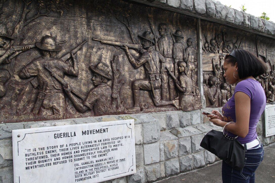 Lance Cpl. Tyrika Bradby, administrative clerk, III MEF, reads a placard of a mural commemorating the lives of Philippine service members who gave their lives on the island of Corregidor in World War II during an educational visit April 25. Several U.S. service members participating in Balikatan '09 spent the day learning about the earlier RP-U.S. history.