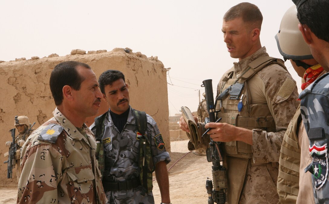 1st Lt. Blaine Barby, a platoon commander with 3rd Light Armored Reconnaissance Battalion, talks to Iraqi police during a visit to Nofali, Iraq, April 25, 2009.  During visits such as this, 3rd LAR Marines can better prepare themselves for any problems that may arise within their sector of the Ninewa province.