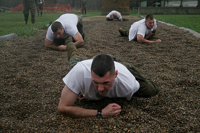Marine Officer Candidates low crawl their way to the end of an obstacle course during Officer Candidate School Preparation weekend at Camp Dodge, Des Moines, Iowa,  April 25. The OCS Prep weekend is designed to give candidates a glimpse into what OCS life is like.