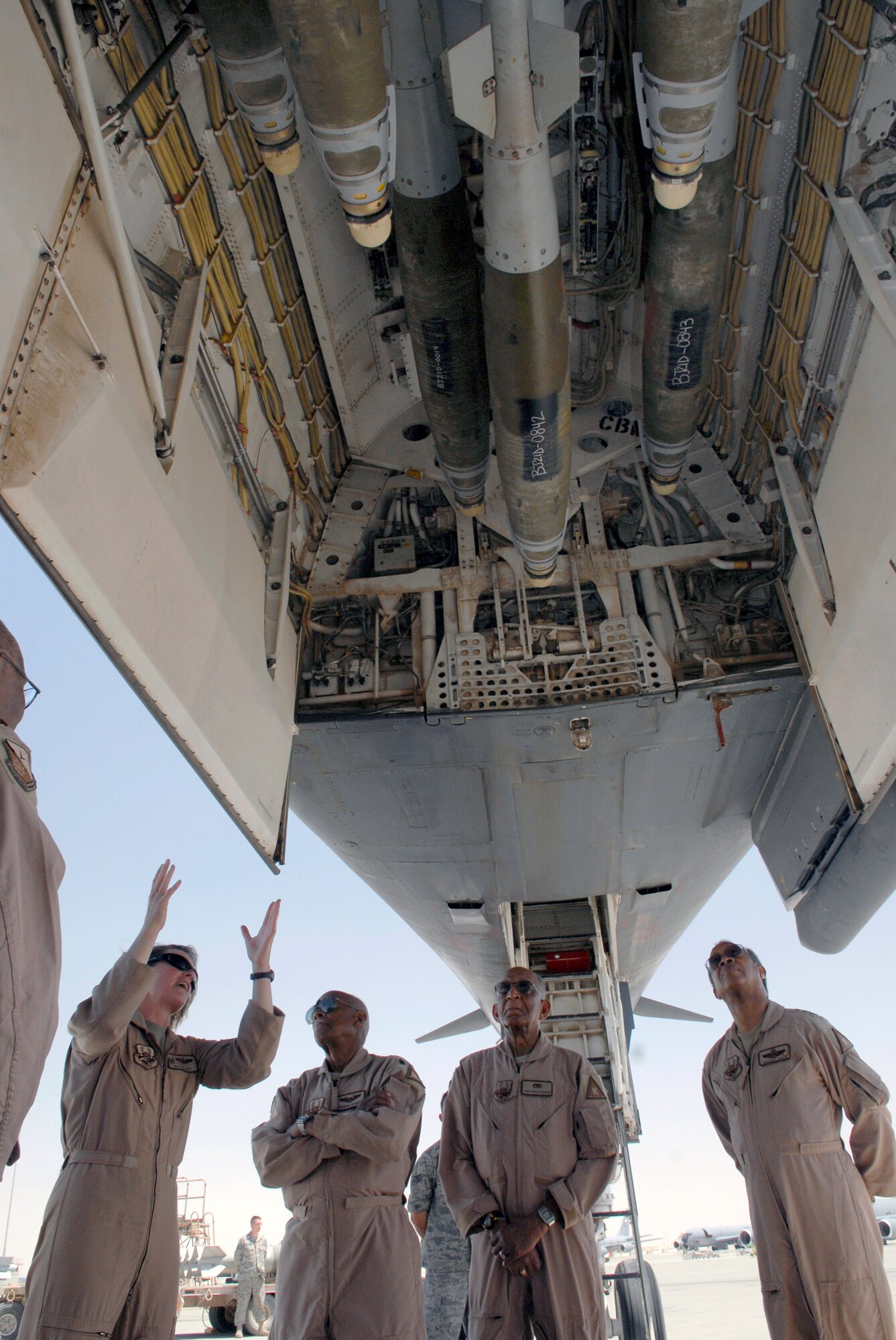 Lt. Col. Jen Fullmer, commander of the 9th Expeditionary Bomber Squadron, shows the forward bomb bay of a B-1B Lancer to retired Lt. Col. Alexander Jefferson, Staff Sgt. Phillip Broom and retired Lt. Gen. Russell Davis during their visit on base April 22 in Southwest Asia. Colonel Jefferson and Sergeant Broom are two original Tuskegee Airmen, and General Davis is the president of the nonprofit Tuskegee Airmen, Inc. (U.S. Air Force photo/Senior Airman Andrew Satran)