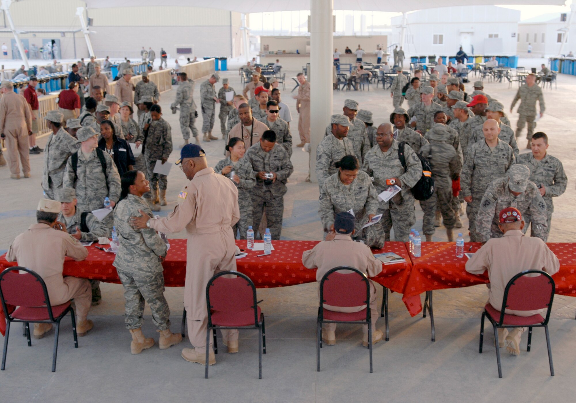 Members of the 379th Air Expeditionary Wing line up for autographs and photos with four original members of the Tuskegee Airmen April 22 at an air base in Southwest Asia.  The members were retired Lt. Cols. Alexander Jefferson and James Warren; retired Maj. George Boyd and former Staff Sgt. Phillip Broome. The Tuskegee Airmen toured the wing's operations center. (U.S. Air Force photo/Senior Airman Andrew Satran)