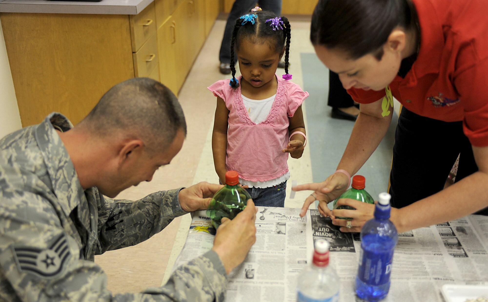 CANNON AIR FORCE BASE, N.M. -- Staff Sgt. Anthony Simpson, 27th Special Operations Civil Engineer Squadron, helps Zarai Lewis plant sunflower seeds at Clovis Carter Library April 23. Sergeant Lewis read stories to children at the library about environmental contributions they that can make for a cleaner planet. This was one of the many events Cannon held from April 16-23. (U.S. Air Force Photo/Airman 1st Class Evelyn Chavez) 