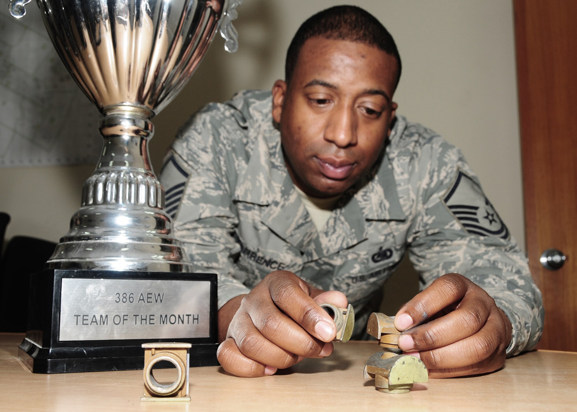 Master Sgt. Richard Tarrence poses with a wing-joint barrel nut April 22 at an air base in Southwest Asia. Sergeant Tarrence was part of a 30-person team assigned to inspect C-130 Hercules for defective barrel nuts and replace them without sacrificing mission effectiveness. The team was named the wng's team of the month for March. The defective barrel nuts removed from the C-130s are now in the team's trophy room. (U.S. Air Force photo/Senior Airman Courtney Richardson)