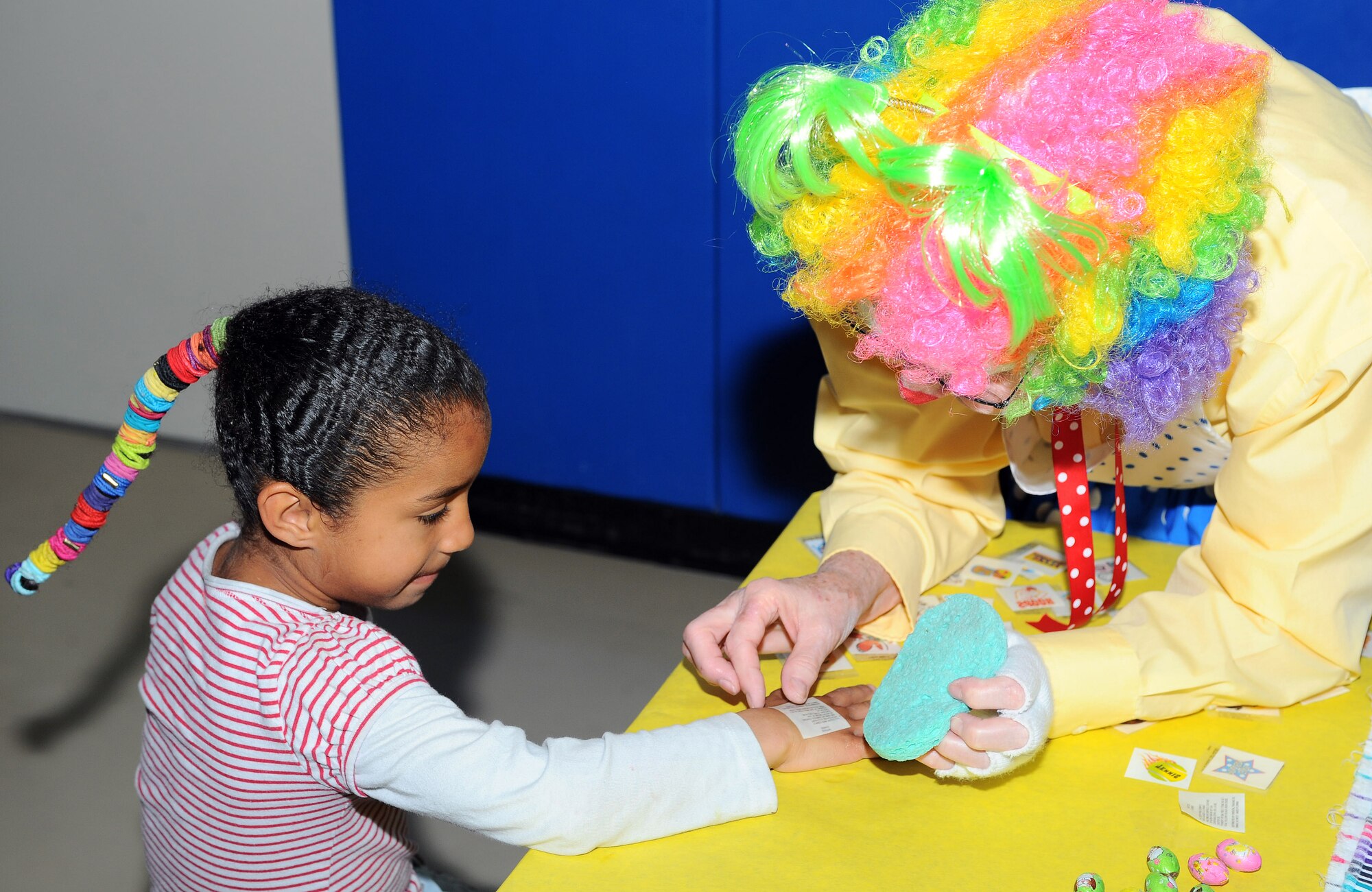 Children get their face and hands painted in addition to getting stickers from clowns at the Holloman Kids Carnival held at the Youth and Teens Center, April 18. The Kids Carnival offered many forms of entertainment for the youth. (U.S Air Force photo/ Airman 1st Class DeAndre Curtiss)
