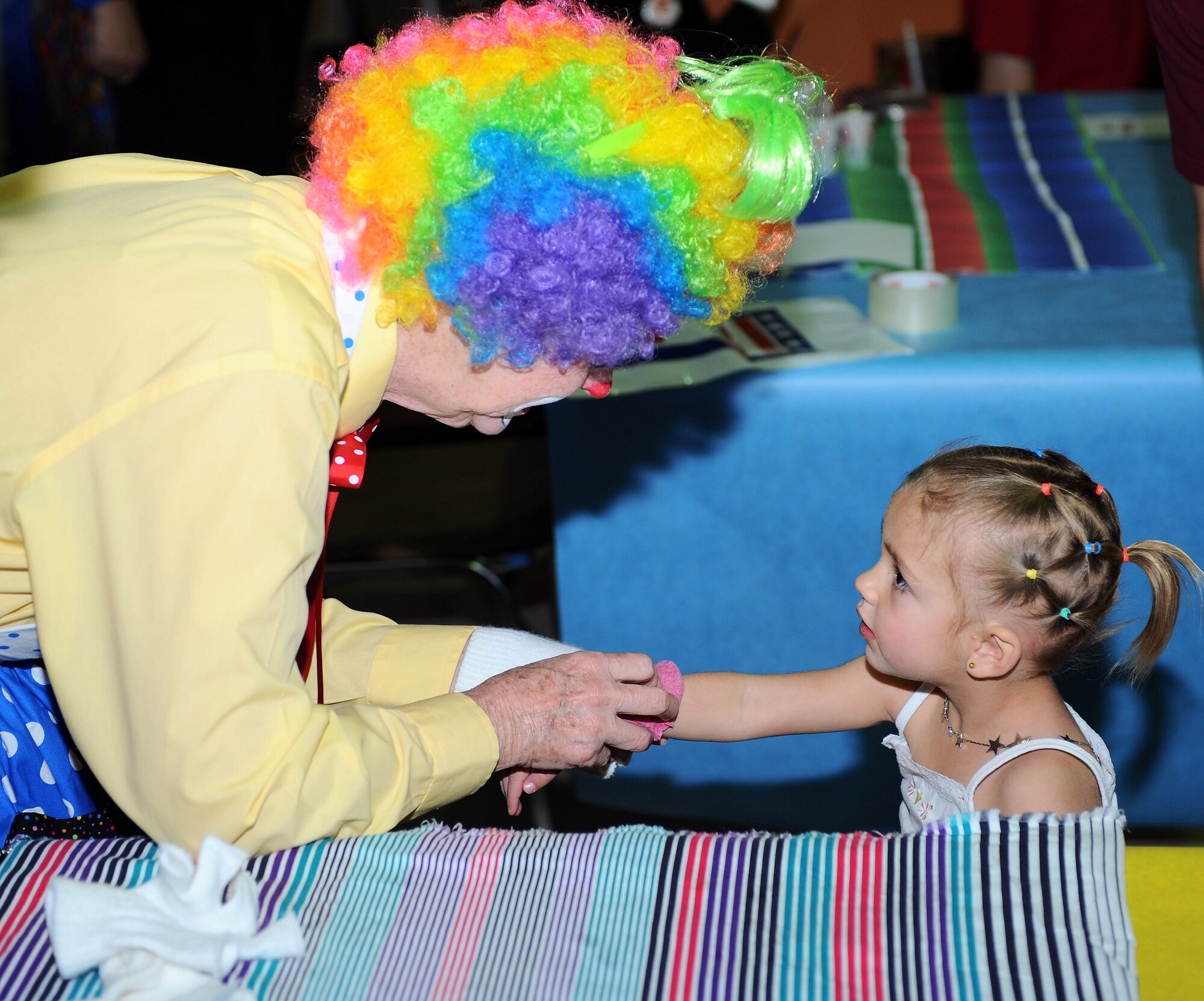 Children get their face and hands painted in addition to getting stickers from clowns at the Holloman Kids Carnival held at the Youth and Teens Center, April 18. The Kids Carnival offered many forms of entertainment for the youth. (U.S Air Force photo/ Airman 1st Class DeAndre Curtiss)