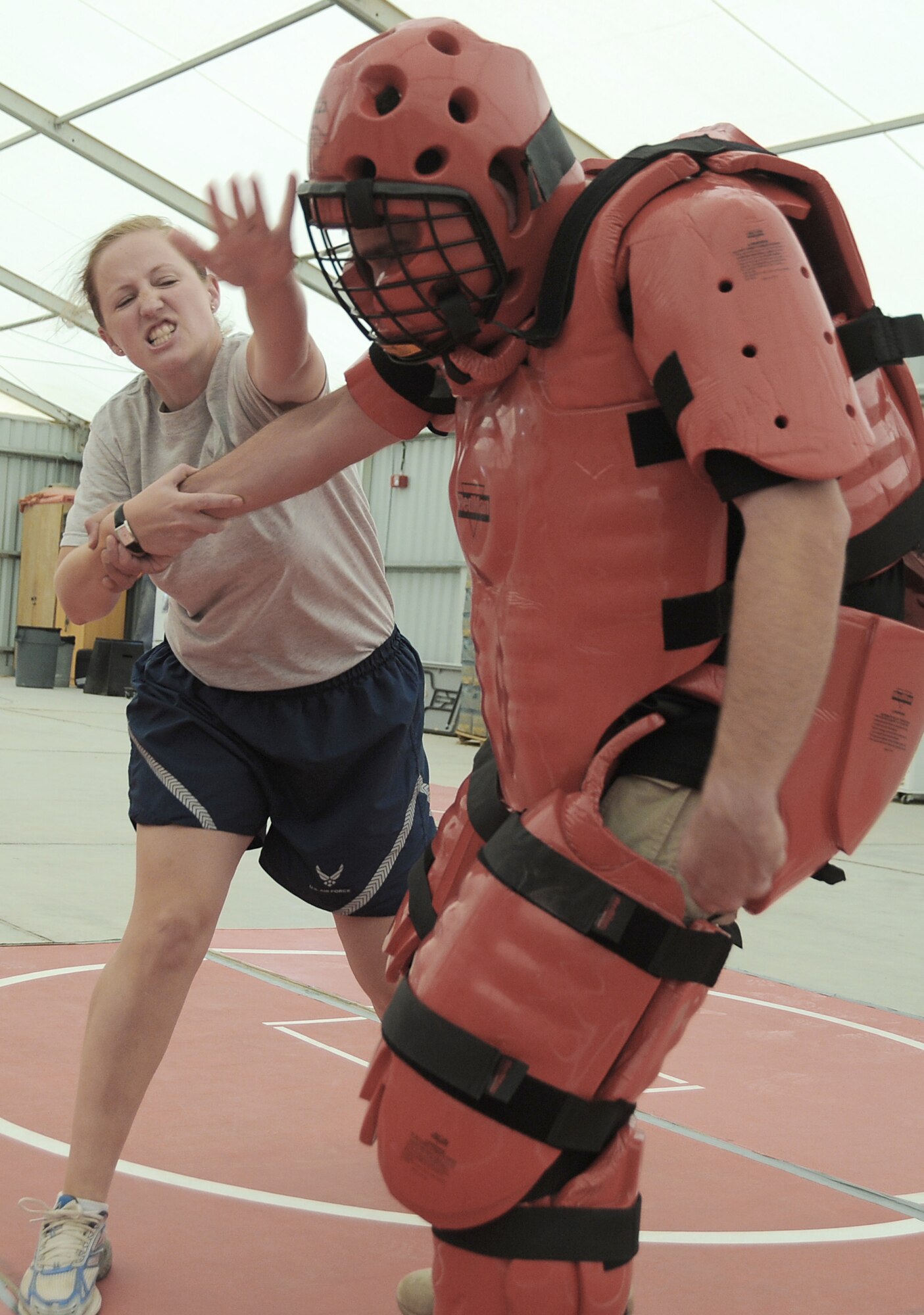 Capt. Jennifer Pearson gives a blow to the head of Rick Baldwin, a contractor posing as the "red man attacker," during self-defense training April 18 at an air base in Southwest Asia. The sexual assault response coordinator sponsored the training that gave students the chance to learn techniques to defend themselves from attack. Captain Pearson is the public affairs officer for the 380th Air Expeditionary Wing, and is deployed from Langley Air Force Base, Va.  (U.S. Air Force photo/Senior Airman Brian J. Ellis)