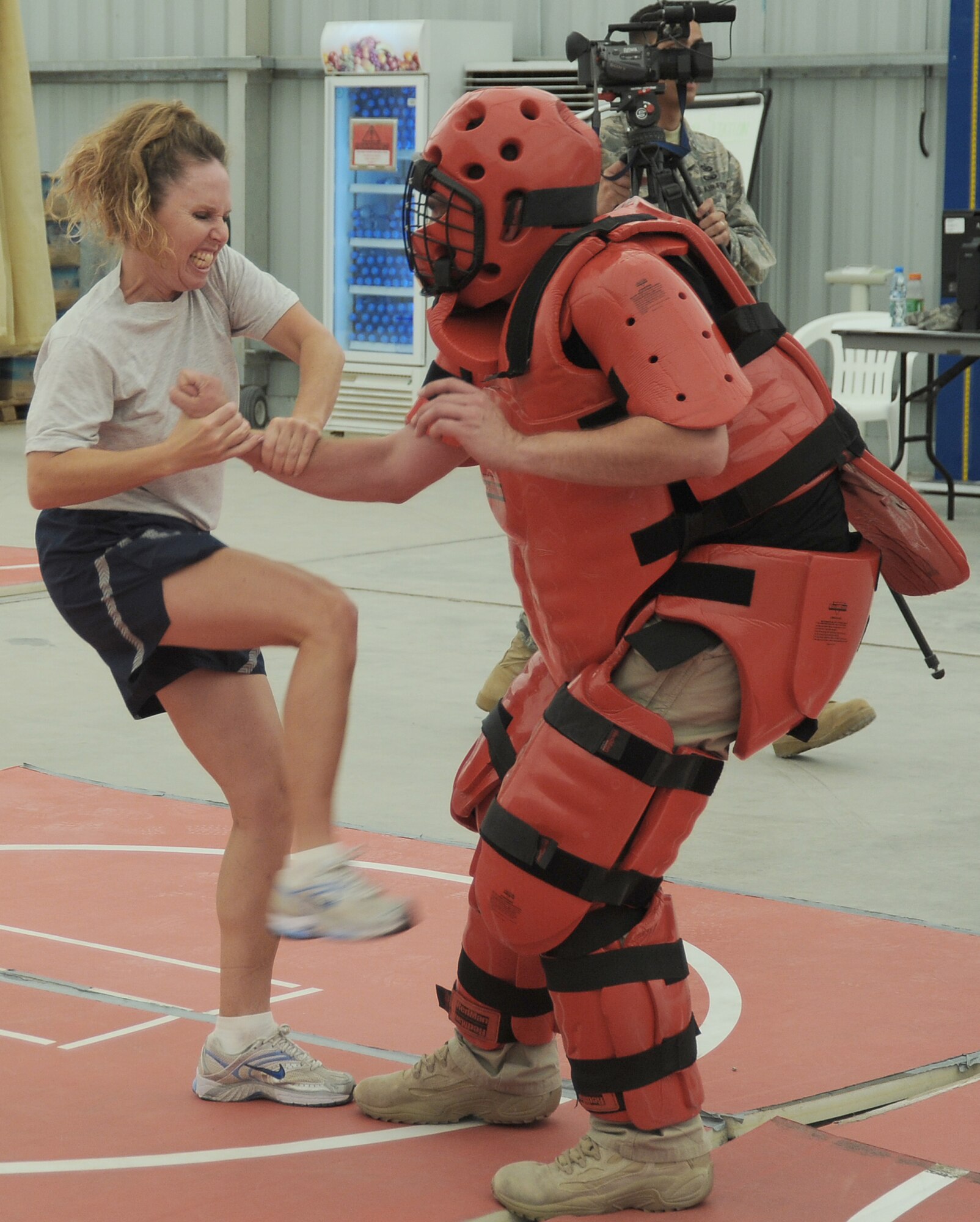 Capt. Sherry Souriolle tries to kick the "red man attacker" played by contractor Rick Baldwin during self-defense training April 18 at an air base in Southwest Asia. Captain Souriolle is the sexual assault response coordinator for the 380th Air Expeditionary Wing and sponsored the training. She is deployed from Los Angeles Air Force Base, Calif. (U.S. Air Force photo/Senior Airman Brian J. Ellis)