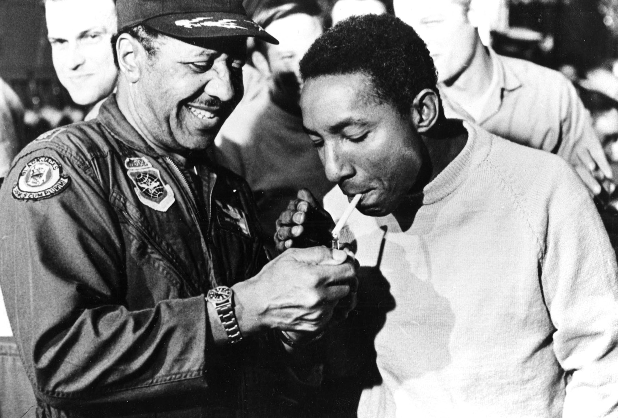 Lt. Col. Warren lighting a cigarette for an "old friend" who was one of the first group of Americans released from POW camp by the North Vietnamese. The items worn by Lt. Col. Warren in this photo are those on display. (U.S. Air Force photo)