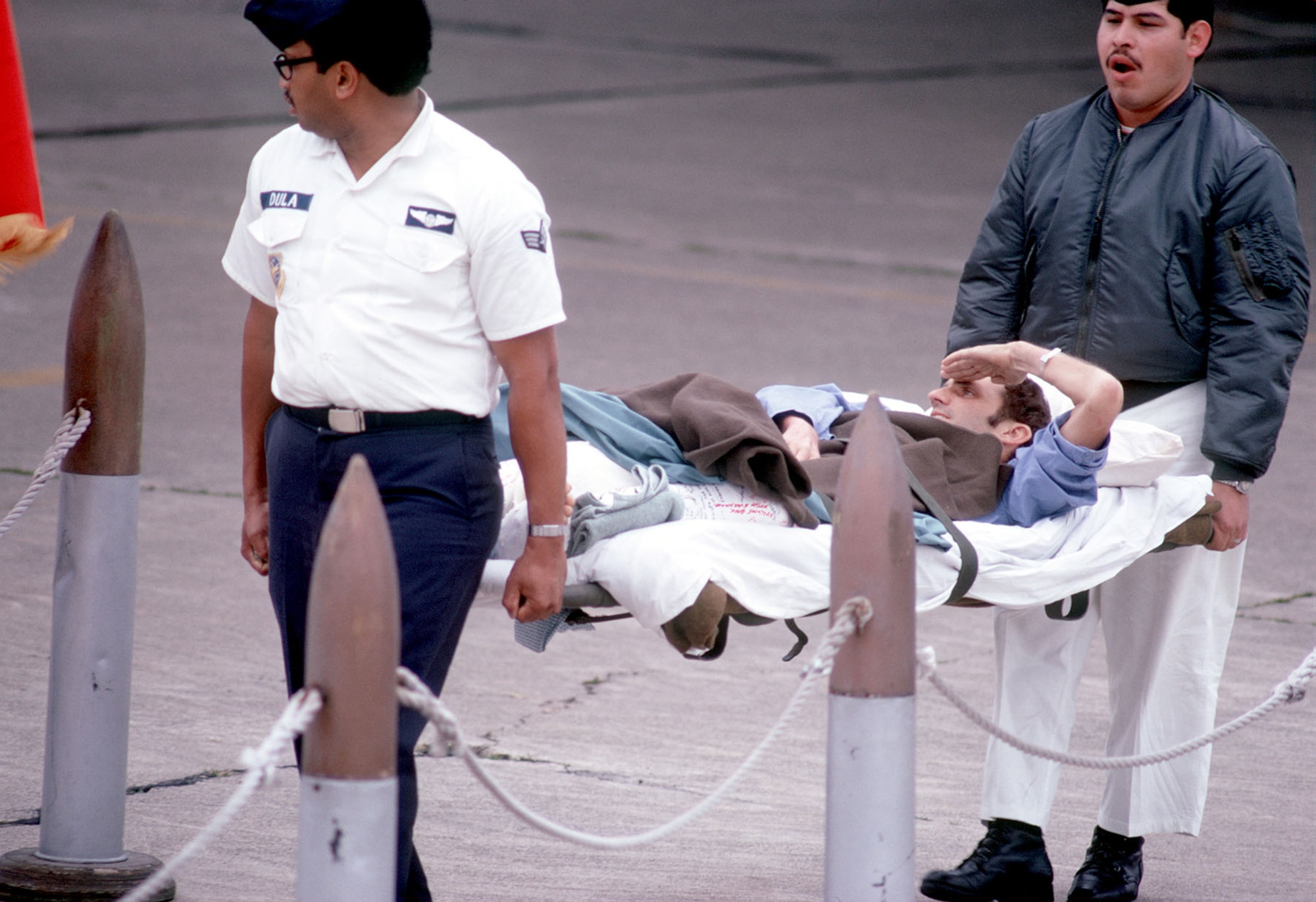 Tech. Sgt. James R. Cook salutes the colors from his stretcher. (U.S. Air Force photo)