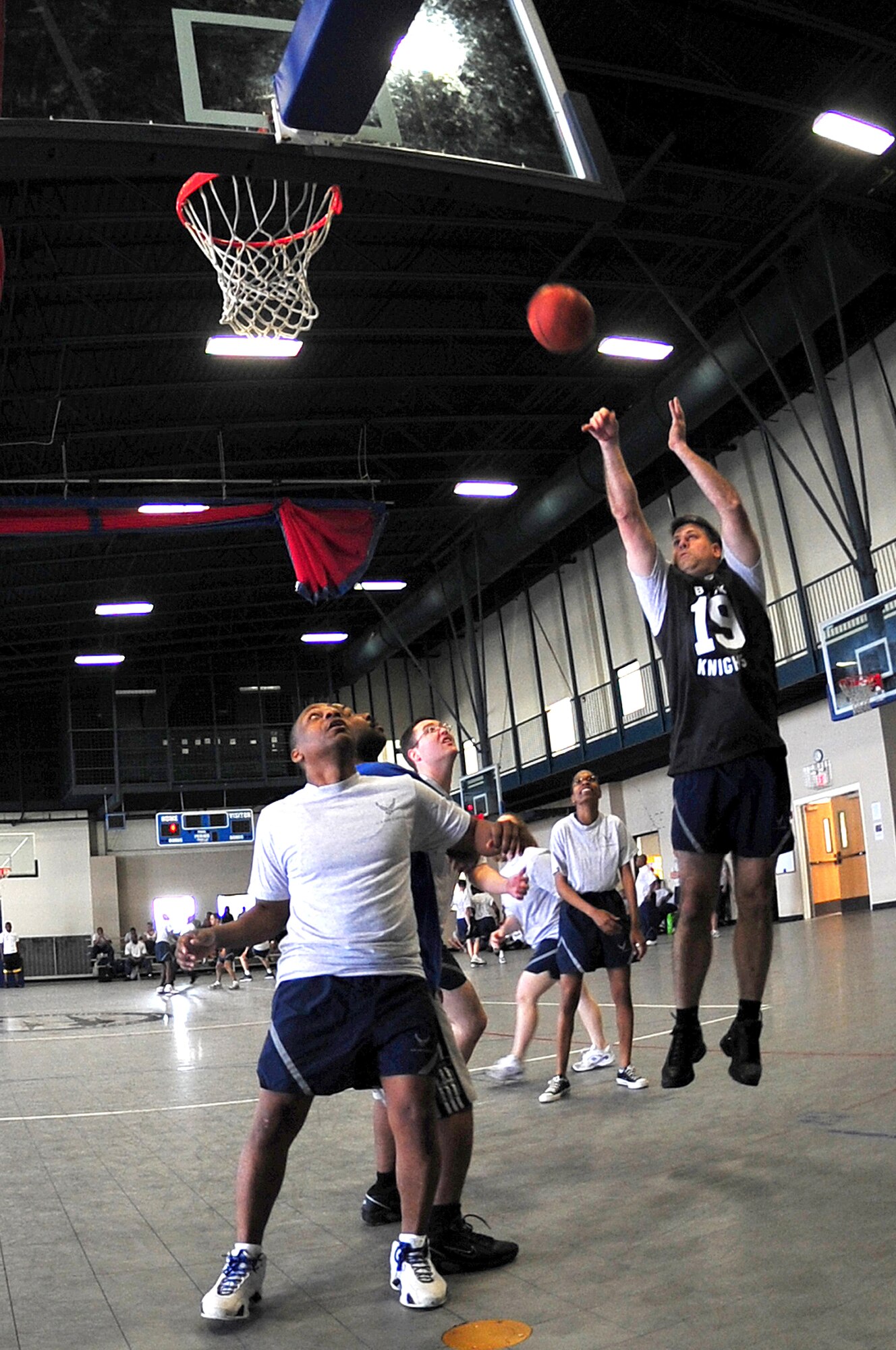 Col. Greg Otey, 19th Airlift Wing commander, goes up for a jump shot while Chief Master Sgt. Anthony Brinkley, 19th Airlift Wing command chief, holds a position under the hoop for a possible re-bound during a 3 on 3 basketball tournament during “Fit to Fight Sports Day” at Little Rock Air Force Base April 17, 2009. The Little Rock AFB Sports Day is a biannual event designed to celebrate fitness and increase the morale of personnel stationed here. (U.S. Air Force photo by Staff Sgt. Chris Willis)