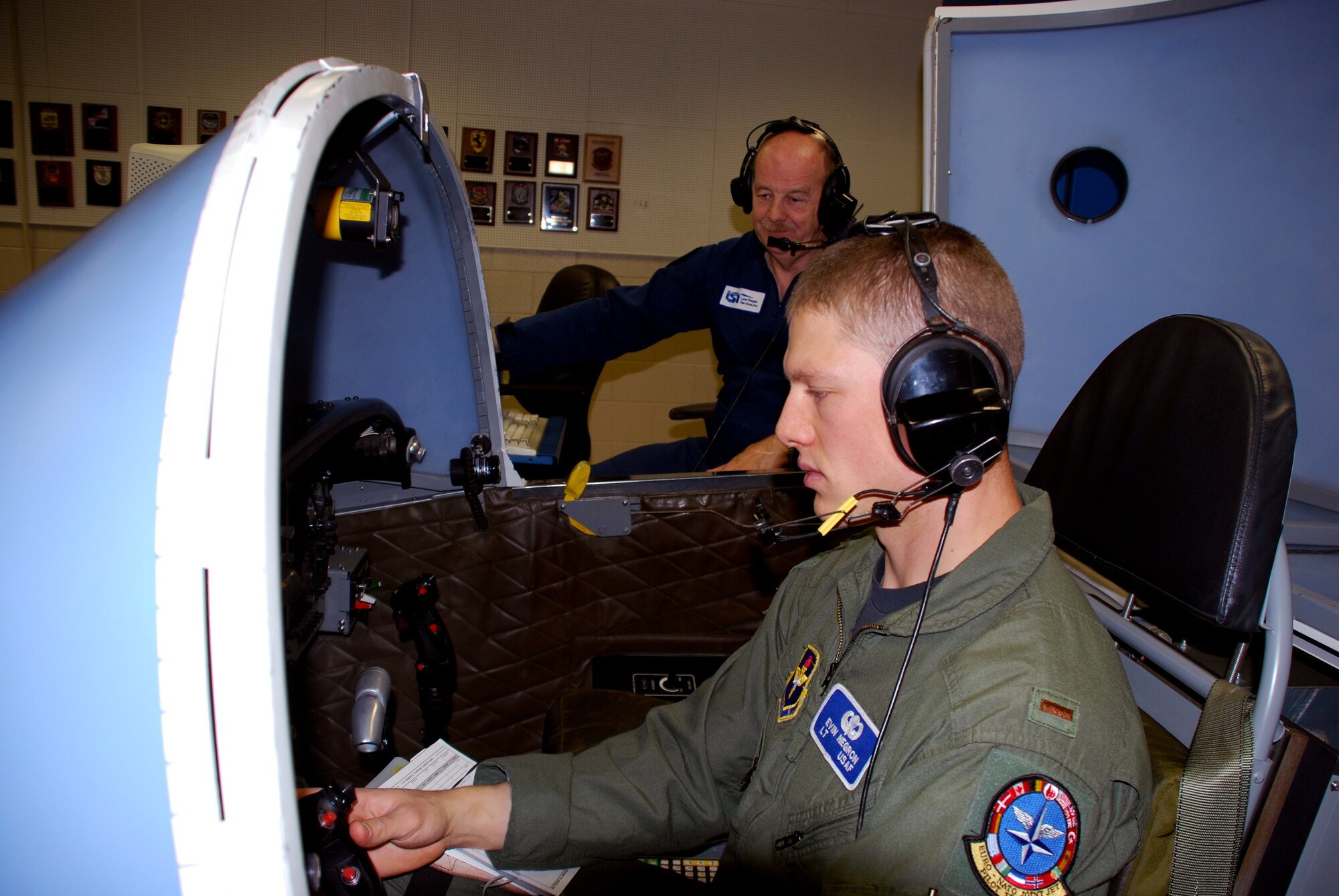 Second Lt. Evan Negron, a T-37 Tweet student pilot at the Euro-NATO Joint Jet Pilot Training Program, conducts the last simulation by a student pilot in the Air Force April 23. The T-6A Texan II will replace the Tweet this summer when the more than 50-year-old introductory trainer retires. Also pictured (blue flight suit) is Wolfgang Ruhl, a simulator instructor at Sheppard. Mr. Ruhl has trained every ENNJPT class since the organization was formed in 1981. (U.S. Air Force photo/John Ingle)