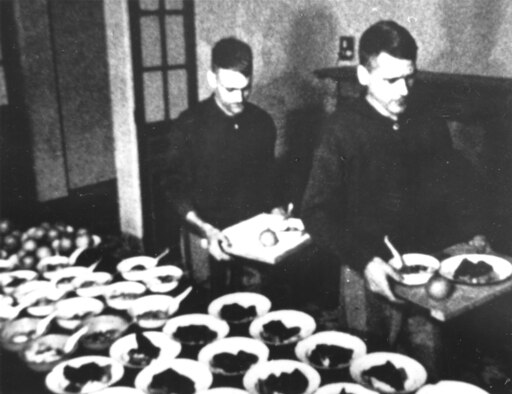 Another propaganda photo showing POWs, USAF Lts. Robert Abbott (left) and James Shively, with plentiful food, which was not the case. (U.S. Air Force photo)