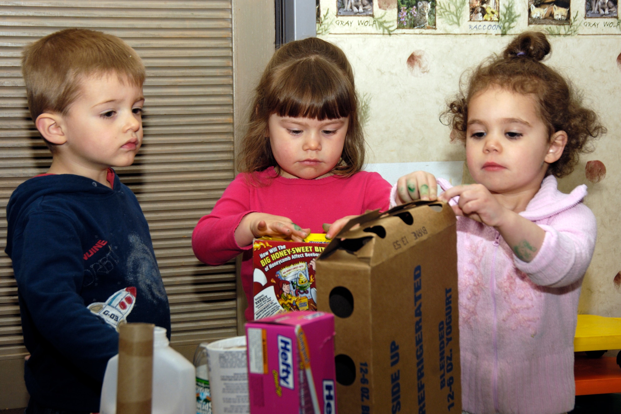 HANSCOM AIR FORCE BASE, Mass. – Children from Room 4 at the Child Development Center learn that recycling is not only good for the environment but a lot of fun too as they create a sculpture from recycled items. Pictured from left to right are CJ Langley, Hannah Quinton and Carleigh Franzoni. (U.S. Air Force photo by Linda LaBonte Britt) 