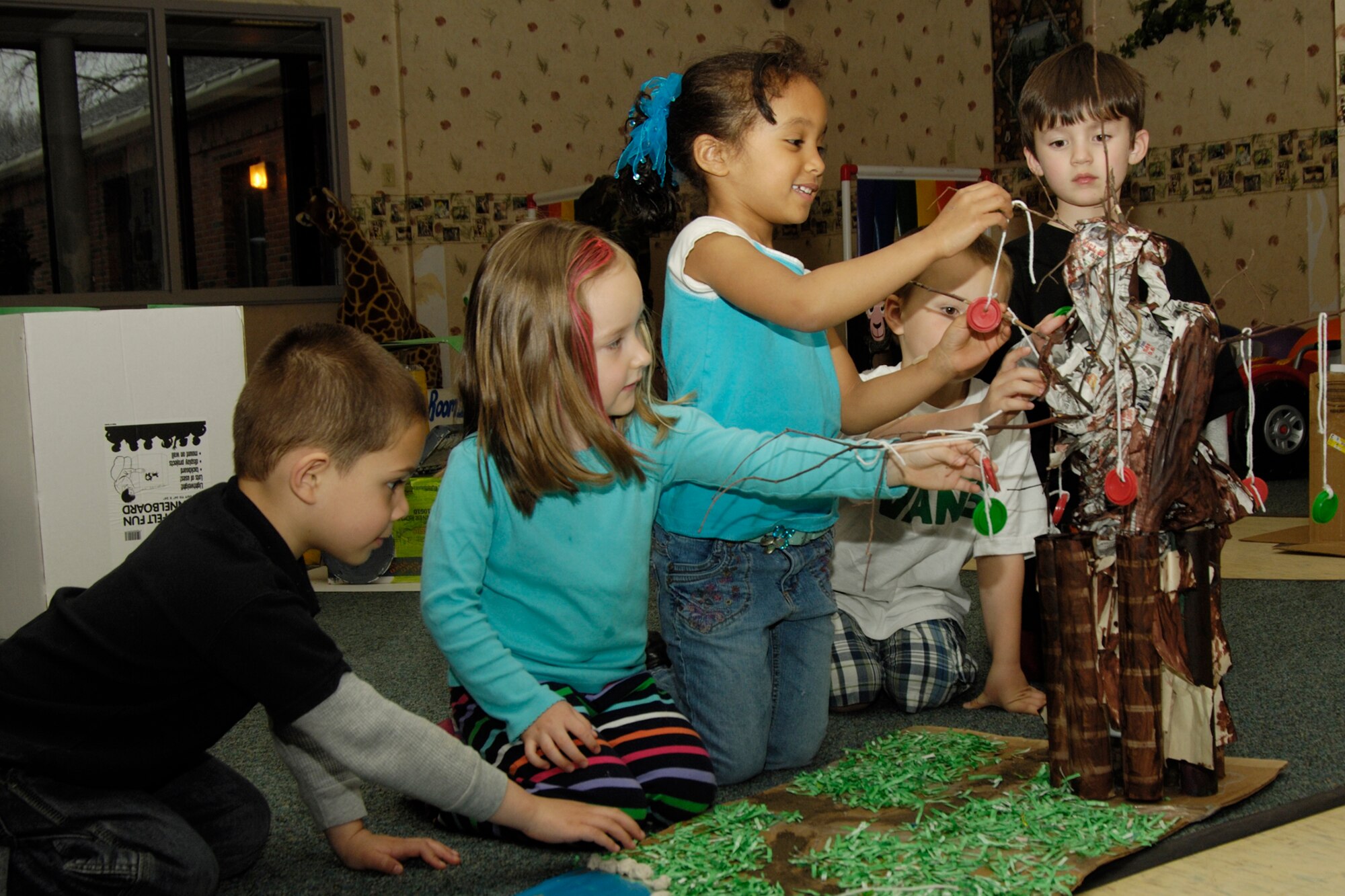 HANSCOM AIR FORCE BASE, Mass. – Hanscom Child Development Center students, from left to right, Elijah Manning, Lauryn Friess, Claire Murphy, Carter Hensley and Timmy Vadnais, put the finishing touches on their recycled art sculpture. Children learned about recycling and taking care of the environment during one of the CDC’s Month of the Military Child activities.  (U.S. Air Force photo by Linda LaBonte Britt)