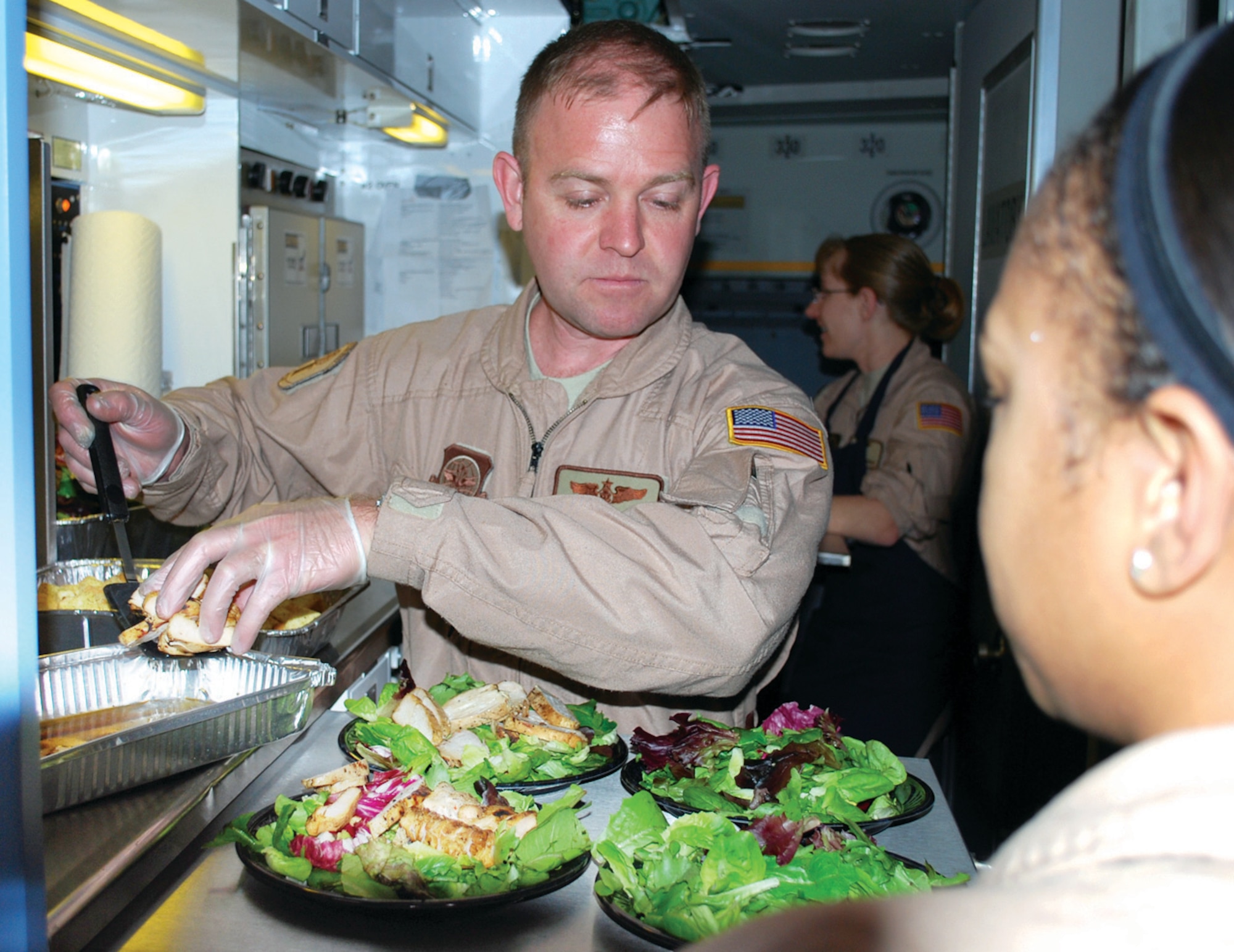 Tech. Sgt. Chris Wilson, 89th Airlift Wing, Operations Support Squadron, prepares salads for passengers during a NATO mission headed to Iraq. (U.S. Air Force photo/ Major Bill Walsh)