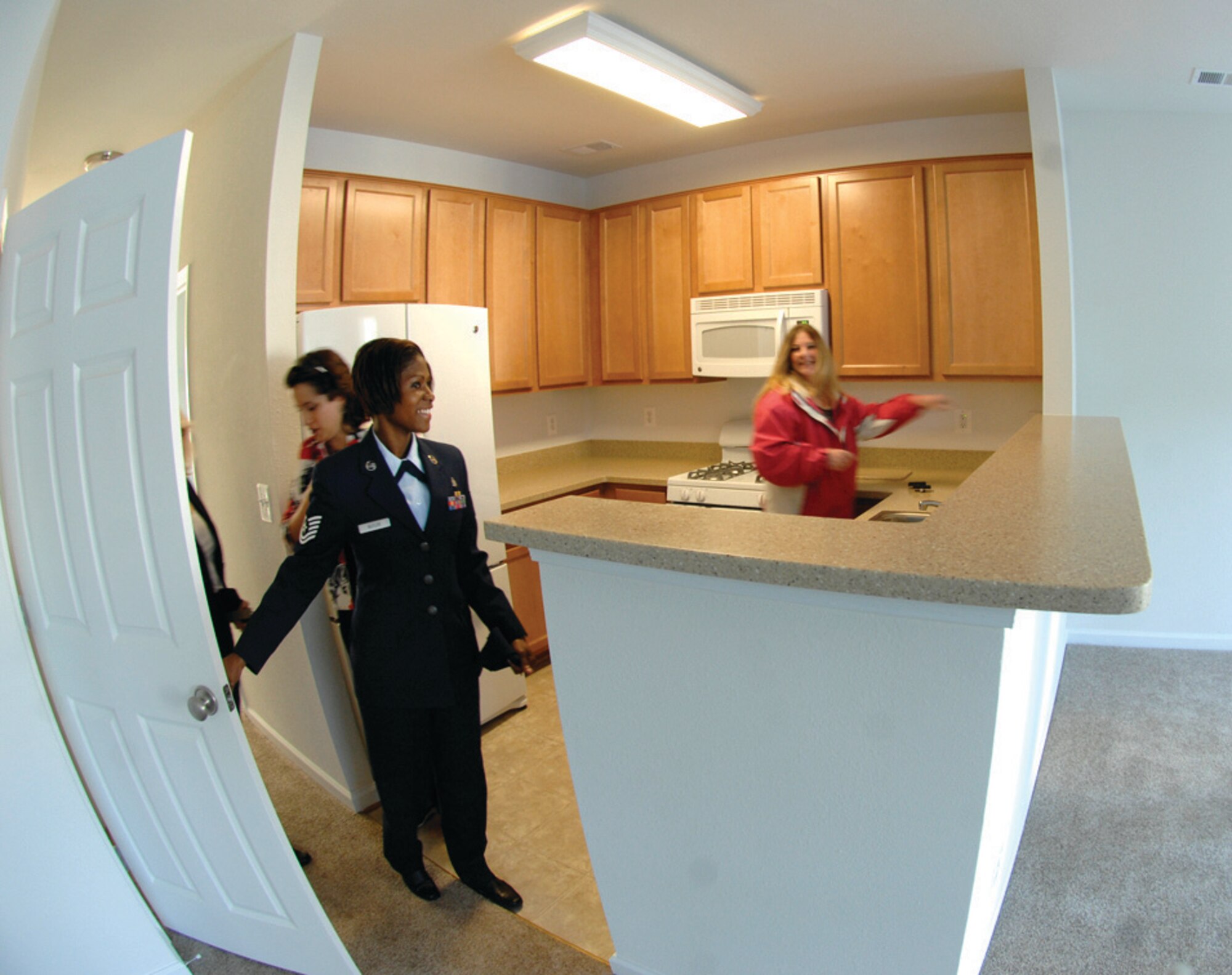 Sergeant Butler tours the interior of her new house while Ms. Redman points out the many amenities. The house is one of the newly built houses that will be reserved for enlisted members who want to live on base. Sergeant Butler is the first NCO to move into a new home. (U.S. Air Force photo/ Senior Airman Giang Nguyen)