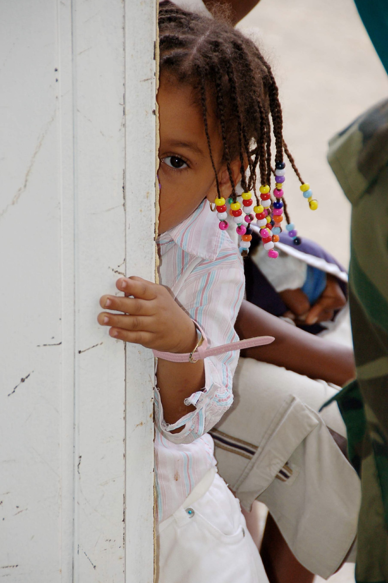 A small child cautiously peers into the pediatrician's room while awaiting her turn in line at a temporary clinic April 22 in Hostos, Dom. Rep., during the medical readiness exercise, Beyond the Horizon 2009 - Caribbean.  The medics treated 2,800 patients during the first three days of the U.S. Southern Command sponsored MEDRETE.  (U.S. Air Force photo/Capt. Ben Sakrisson) 