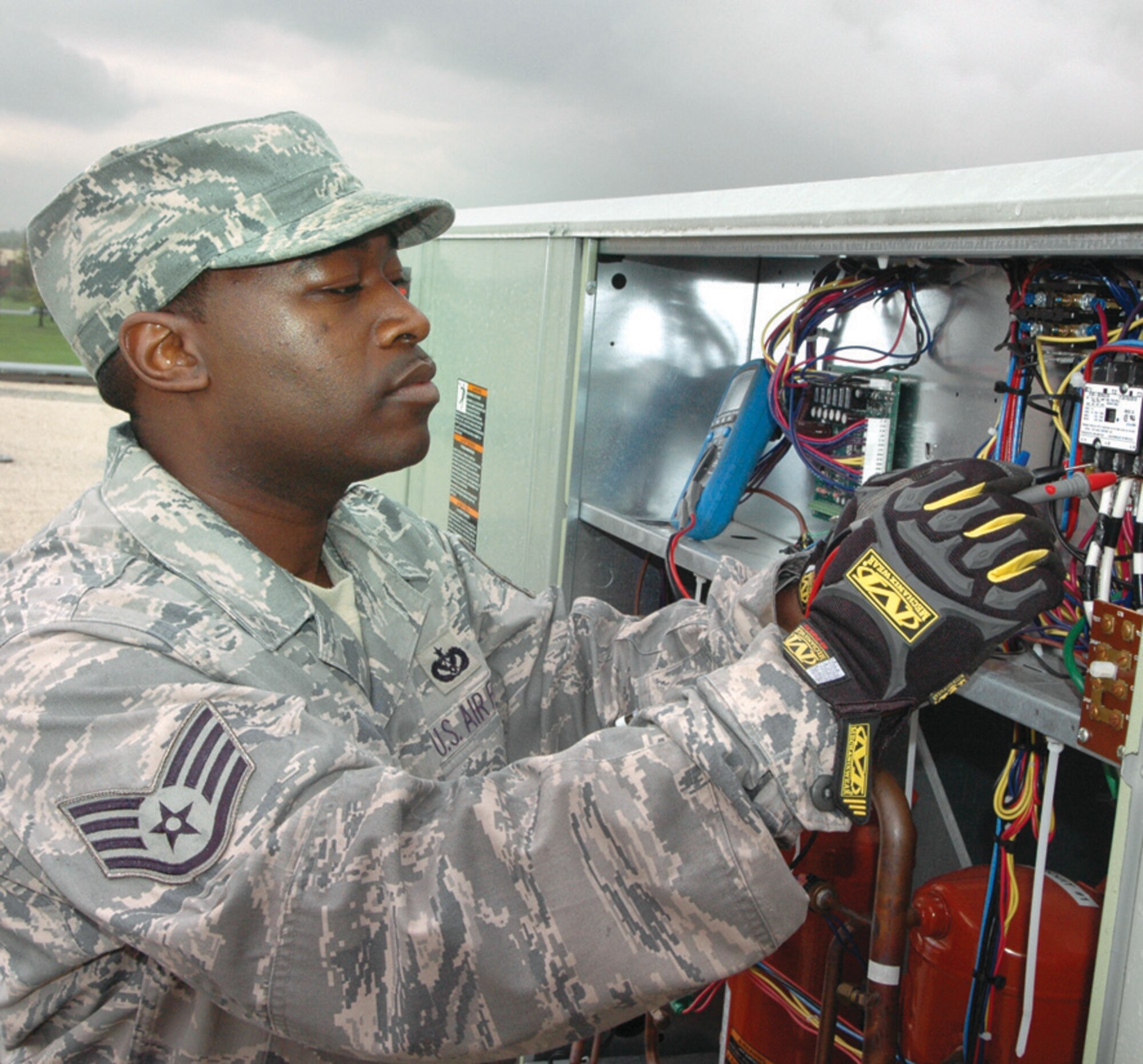 Staff Sgt. Andrew Baines, 316th Civil Engineer Squadron heating and air conditioning craftsman, uses a multimeter to troubleshoot a package air conditioning unit on the roof of the 316th Wing, Bldg. 1535, Wednesday. (U.S. Air Force photo/ Bobby Jones)