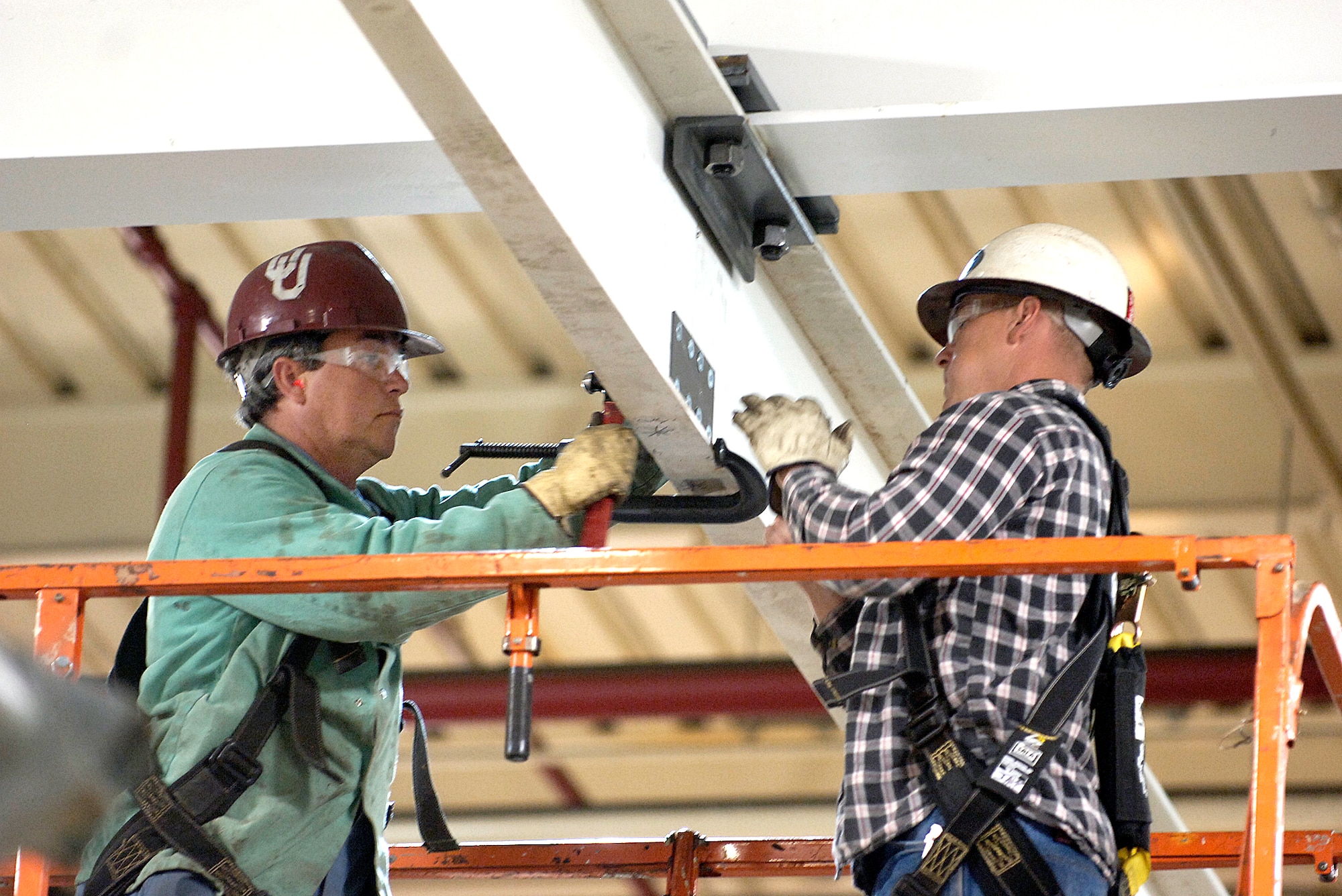Ron Ford, left, and Jake Taron join two 700-pound beams high above the future home of the TF33 engine shop in the Tinker Aerospace Complex. The beams are part of the overhead hoist for shop cranes. The 76th Maintenance Support Group workers are close to finishing their transformation of a corner of the TAC into a bright work area for the first shop scheduled to move to the facility. (Air Force photo by Margo Wright) 