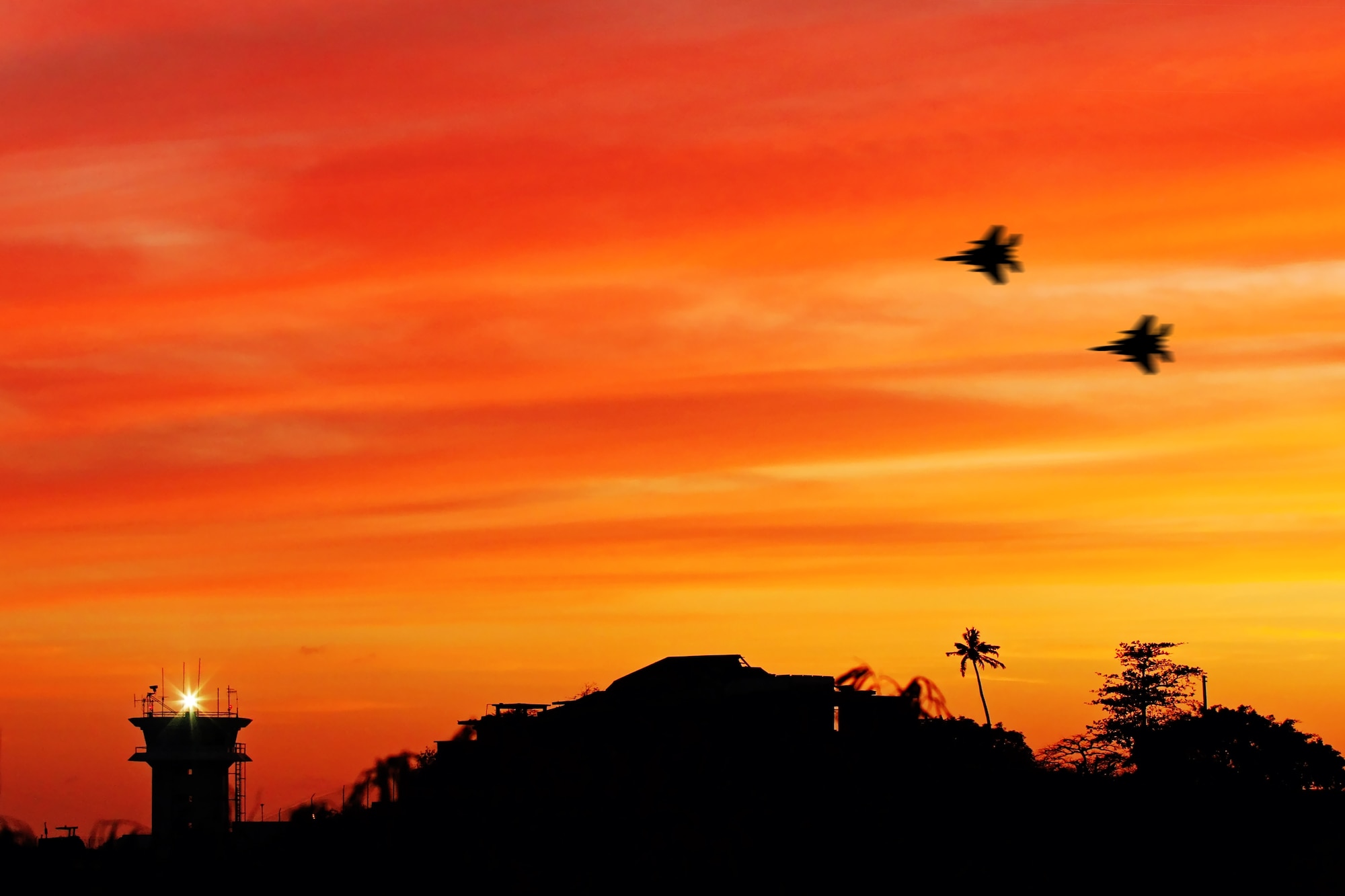 Two F-15s from the 33rd Fighter Wing fly over Port Salines International Airport, Grenada, during their temporary duty there to provide aerial security support for Summit of the Americas conference. Airmen started arriving March 27 to survey and set up a bare base and returned by April 24. The wing deployed 10 aircraft and 125 personnel to join the 190 Airmen from 10 different bases plus international partners. (Courtesy photo by Joshua Yetman)