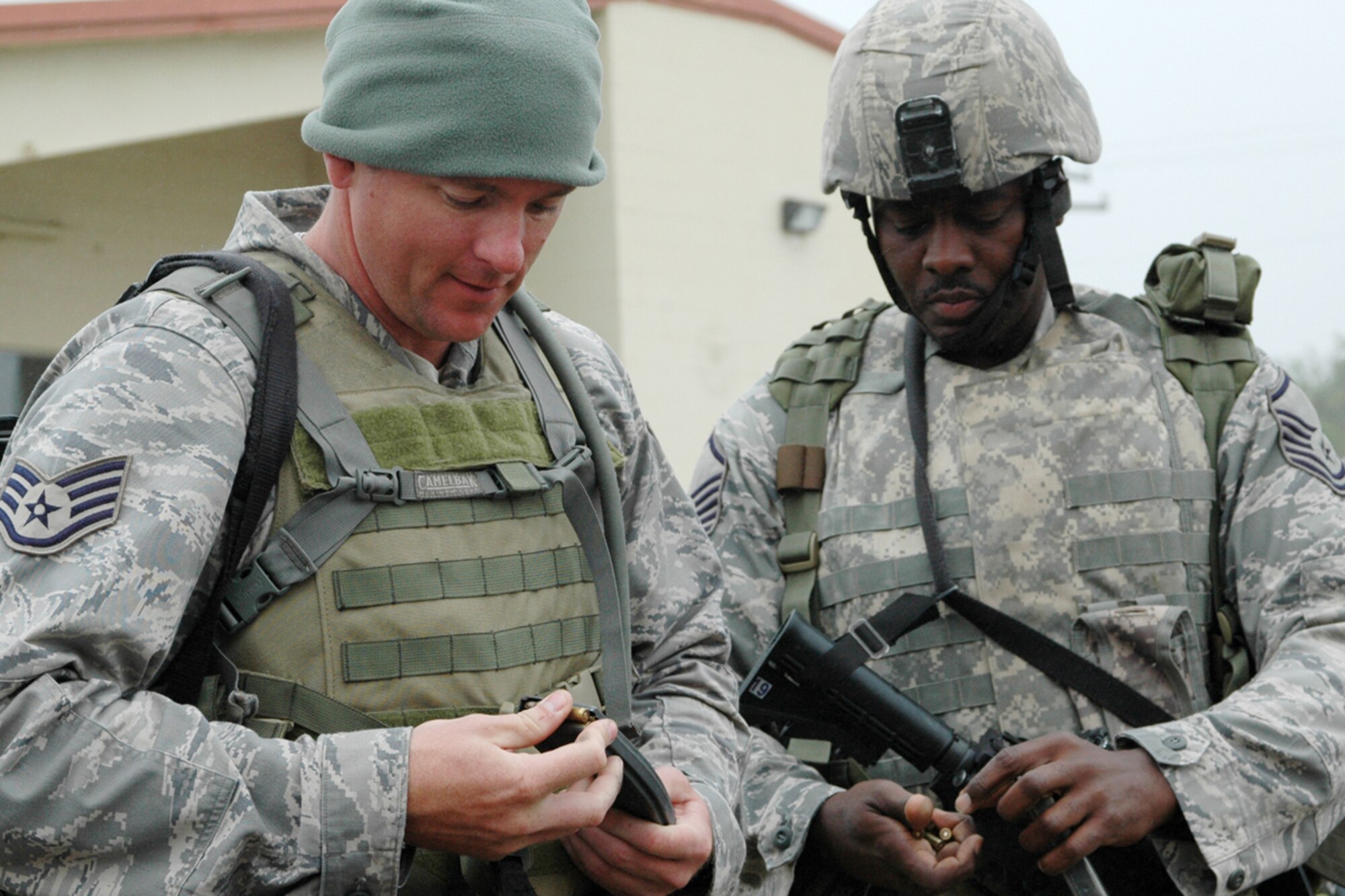 Staff Sgt. John Higginbotham and Master Sgt. Simmie Brown, both members of the 917th Security Forces Squadron, load their weapons before a field exercise as part of Patriot Defender at Fort Wolters, Texas, March 26, 2009.  The two-week class, designed as sustainment training for security forces members, consists of training in areas such as urban operations, mounted operations and land navigation. (US Air Force photo/Master Sgt. Mary Hinson)
