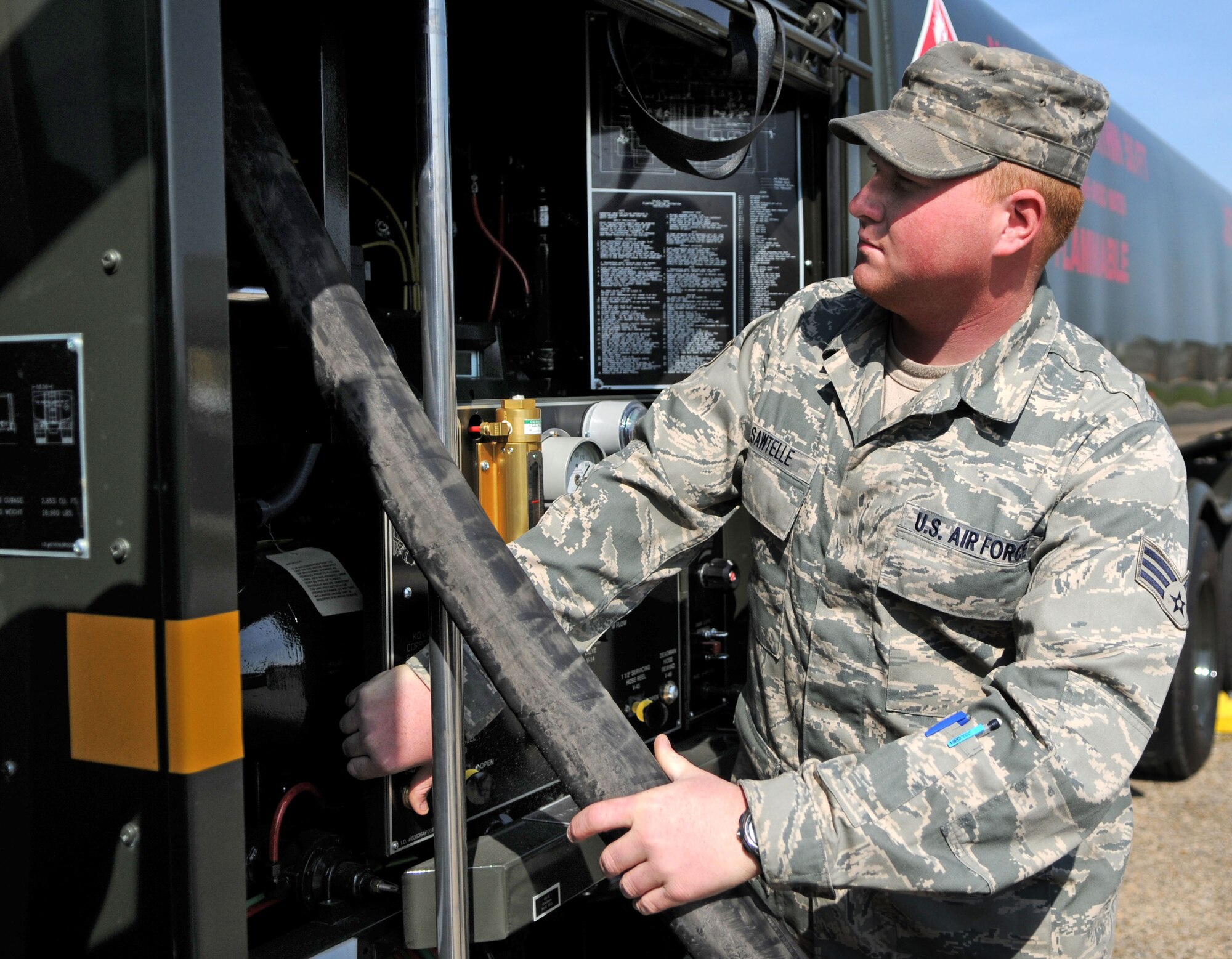 Senior Airman Mark Sawtelle guides a fuel hose back onto its spool on one of the 100th Logistics Readiness Squadron fuels maintenance shop’s five new fuel trucks.   It takes approximately four of the trucks, which can each carry 6,000 gallons of jet fuel, to fill an empty KC-135.  (U.S. Air Force photo by Staff Sgt. Austin M. May)