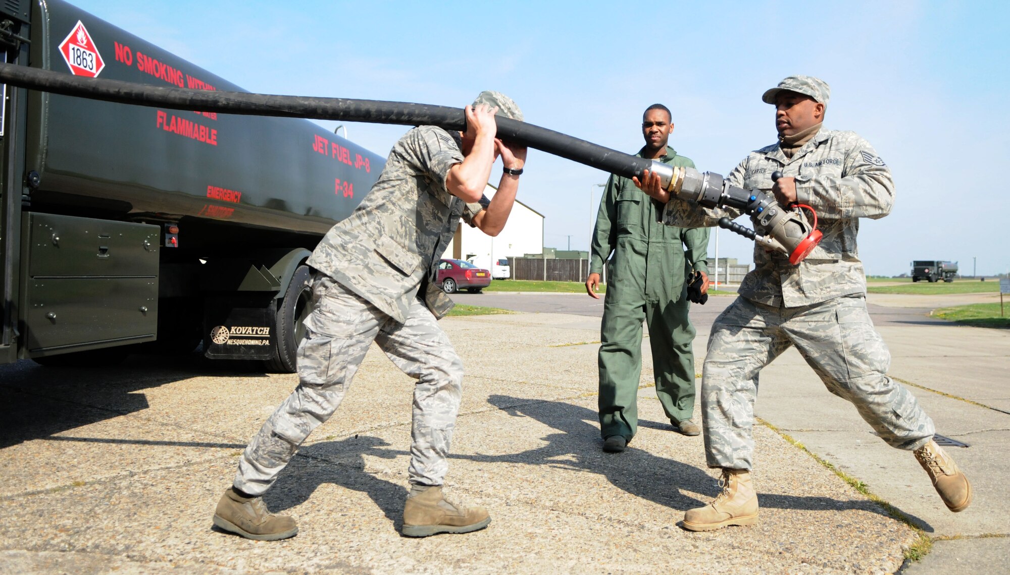 Staff Sgt. O.C. Carter, assisted by Senior Airman Skyler Beadle and observed by Airman Basic Brian Roy, pulls the end of a fuel hose off a spool on one of the 100th Logistics Readiness Squadron fuels maintenance shop’s five new fuel trucks.   The trucks can each hold 6,000 gallons of jet fuel and are able to pump it out at about 600 gallons a minute.  (U.S. Air Force photo by Staff Sgt. Austin M. May)