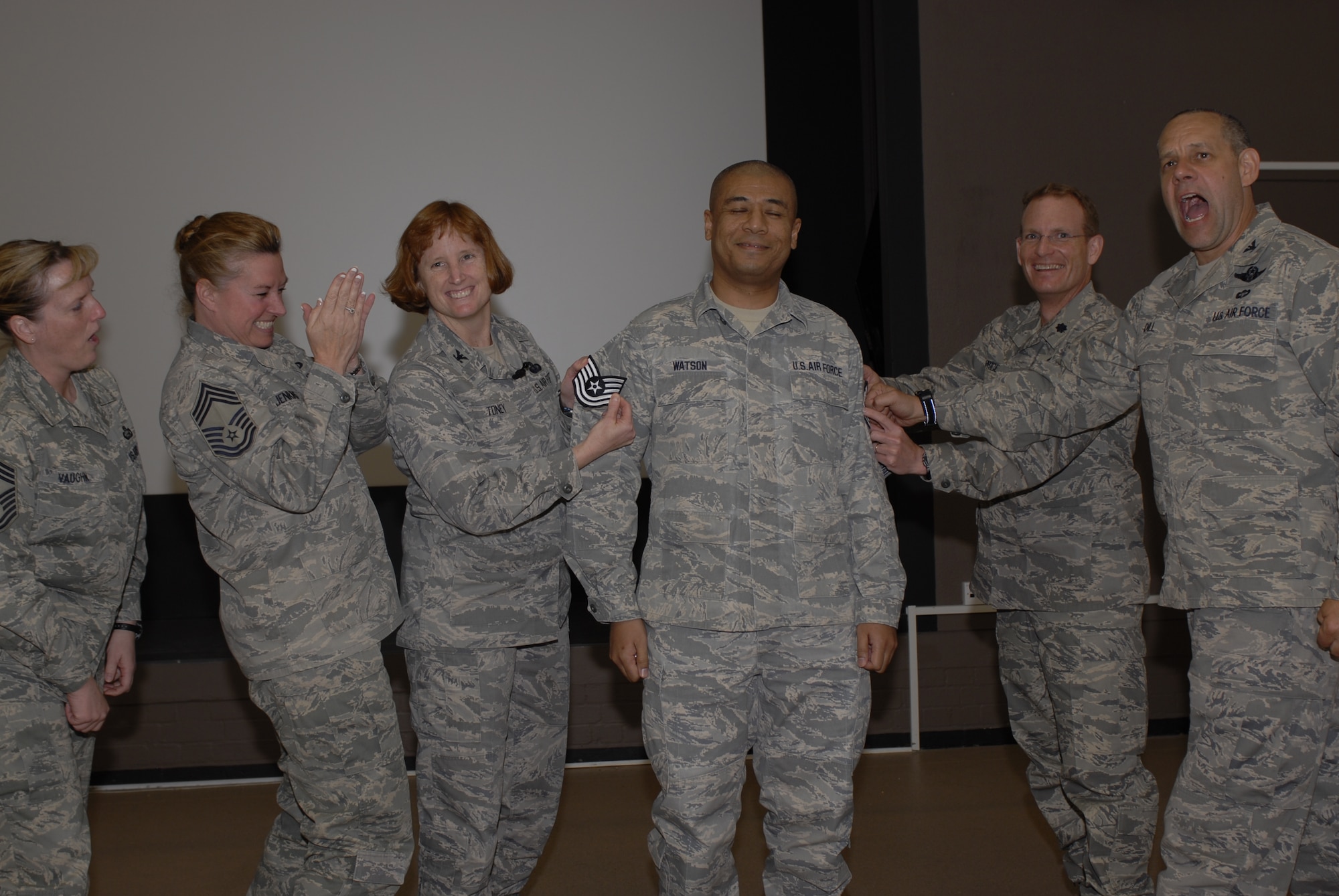 Tech. Sgt. Robert Watson gets the surprise of his career when Col. Kimberly Toney tacked on new stripes during a April 20 Commander's Call. Sergeant Watson, from the 420th Air Base Squadron's Commander's Support Staff, was promoted under the Stripes for Exceptional Performers program. Command Chief Master Sgt. Maria Vaughn, 501st Combat Support Wing, Chief Master Sgt. Sherry Jenkins, 420th Air Base Group superintendent, Colonel Toney, 501st Combat Support Wing commander, Lt Col. Ryan Price, 420th Air Base Squadron commander and Col. Joseph Dill, 420th Air Base Group commander congratulate Sergeant Watson on his accomplishment.
