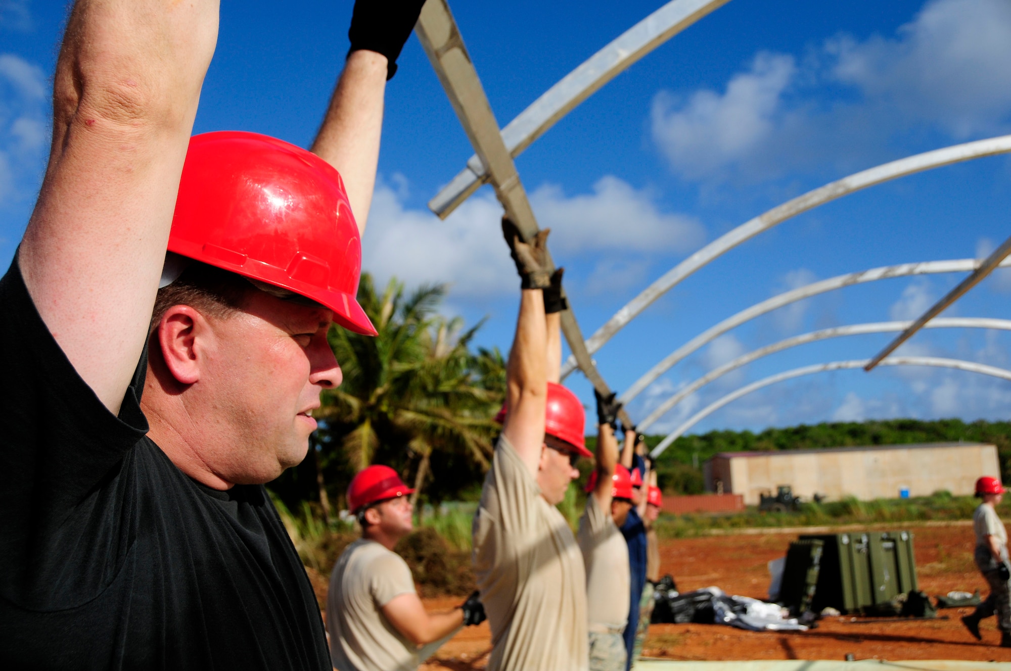 ANDERSEN AIR FORCE BASE, Guam - Master Sgt. Wesley Willand, 554th RED HORSE first sergeant, gives a helping hand to his Airmen as they construct the framework of one of 12 tents during their field training exercise at Northwest Field April 22. The Rapid Engineer Deployable Heavy Operations Repair Squadron Engineer participated in a two day field training exercise to hone expeditionary skills to open a base in any environment. (U.S. Air Force photo by Airman 1st Class Courtney Witt)