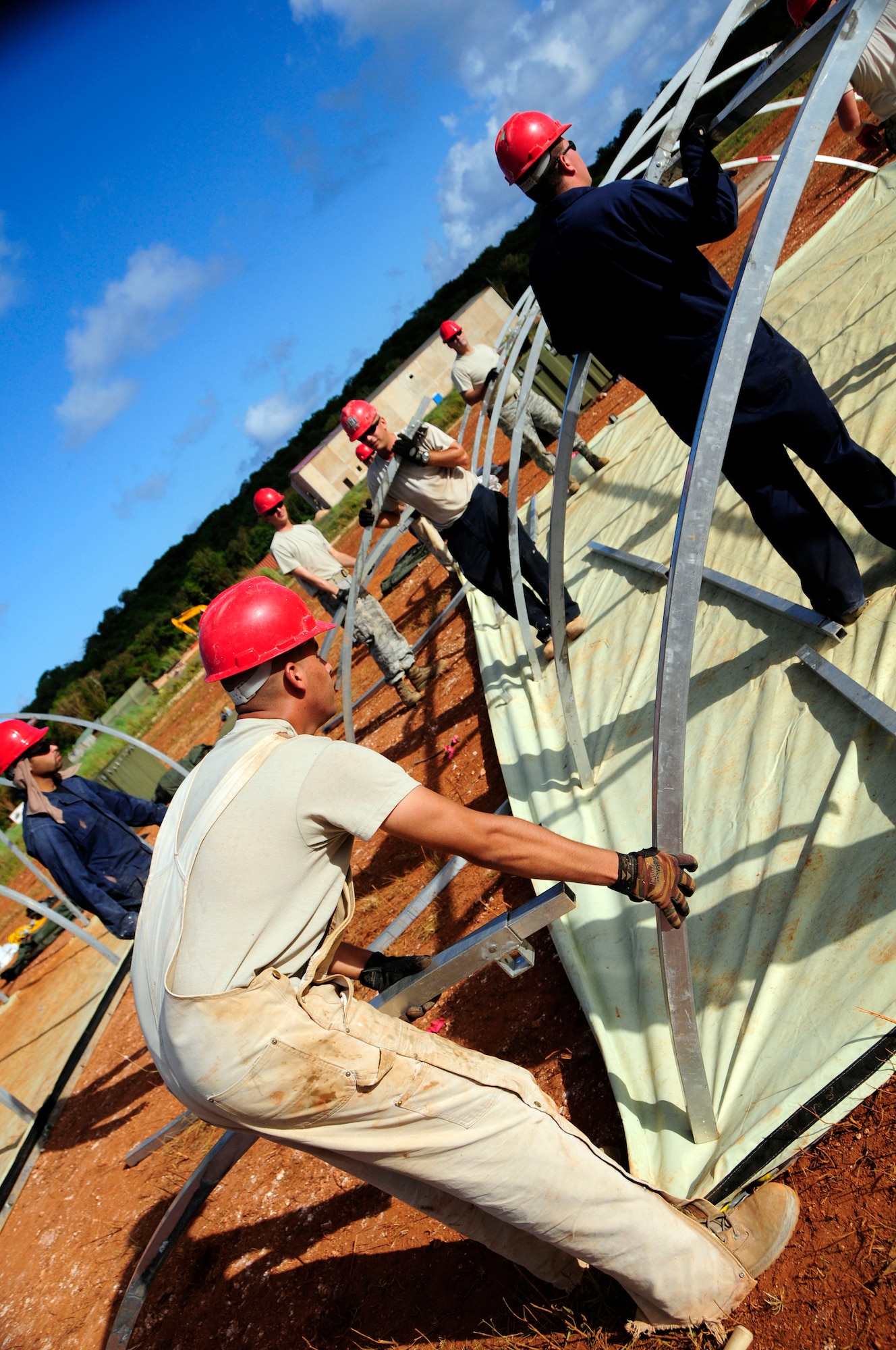 ANDERSEN AIR FORCE BASE, Guam - Airmen of the 554th RED HORSE work together to construct 12 tents as part of their field training exercise at Northwest Field April 22. The Rapid Engineer Deployable Heavy Operations Repair Squadron Engineer participated in a two day field training exercise to hone expeditionary skills to open a base in any environment. (U.S. Air Force photo by Airman 1st Class Courtney Witt)
