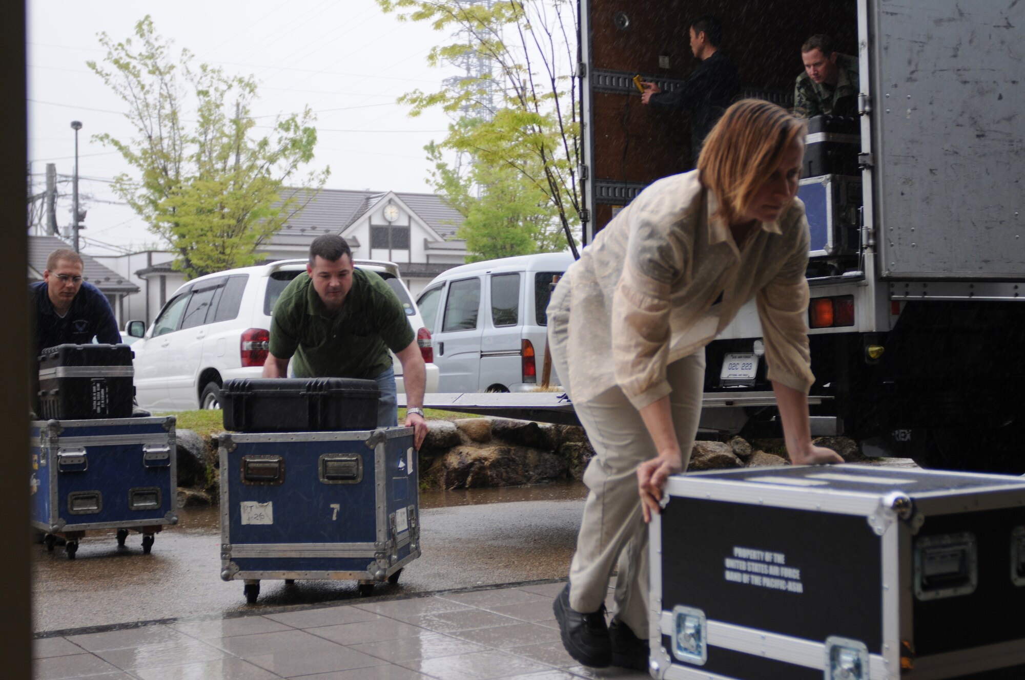 KAKAMIGAHARA CITY, Japan -- U. S. Air Force Band of the Pacific-Asia members unload equipment April 21 before a concert here as part of a five-city tour through southern Japan. The band enhances goodwill and furthers mutual respect for cultural differences between the citizens of Japan and the United States by performing numerous concerts in the Japanese community. (U.S. Air Force photo/Tech. Sgt. Kimberly Spinner)
