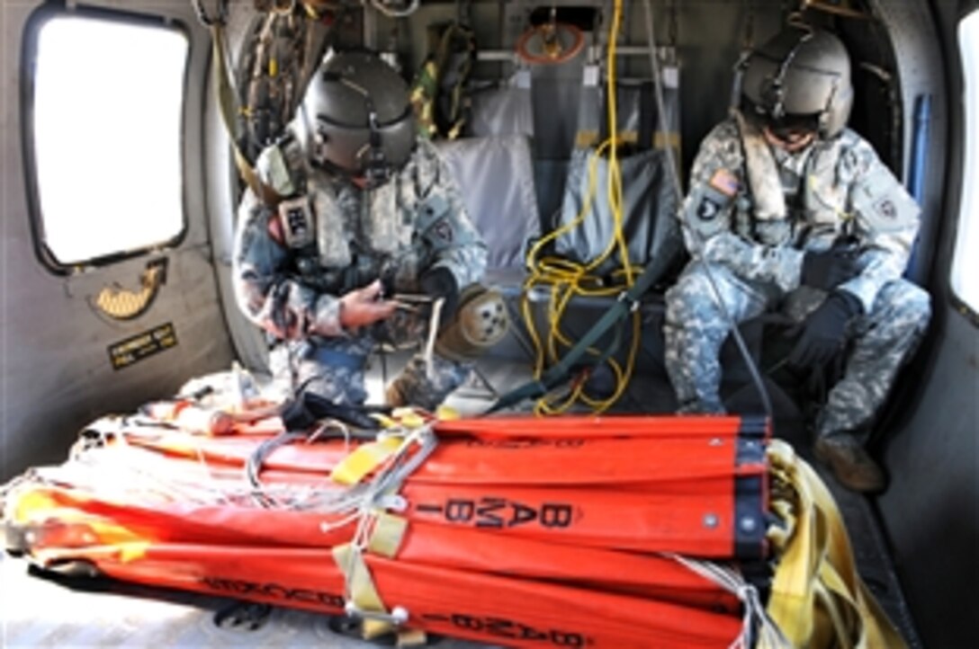 North Carolina Army National Guard Sgt. Joseph Elmore, right, and Staff Sgt.  Robin McDaniel attach cables to a Bambi Bucket to be dropped onto fires nearby Myrtle Beach, S.C., April 23, 2009. Four UH-60 Blackhawk helicopters and crews from the North Carolina Army National Guard's Company C, 1st Aviation Assault Battalion, 131st Aviation Regiment, based in Salisbury, N.C., have been deployed to use the orange-colored buckets to help extinguish the wildfires.