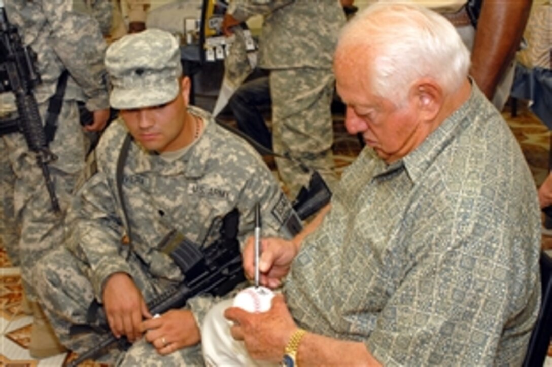 U.S. Army Spc. Francisco Rivera watches as Tommy Lasorda, retired Los Angeles Dodgers manager, autographs a ball. Lasorda was one of five guests to visit with soldiers on Forward Operating Base Fenty, Afghanistan, during a USO spring tour, April 23, 2009. Rivera is assigned to the 1st Infantry Division's 3rd Brigade Combat Team.