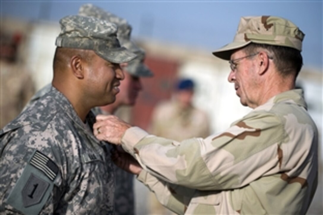 U.S. Navy Adm. Mike Mullen, chairman of the Joint Chiefs of Staff, pins the Combat Action Badge on Master Sgt. Fenumiai Ilalio, Forward Operating Base Walton, Kandahar, Afghanistan, April 24, 2009. Mullen is on a six-day tour of the U.S. Central Command area of responsibility to escort a USO tour, meet with counterparts and visit troops.