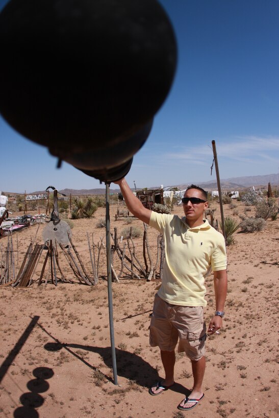 Lance Cpl. Aaron Kristopik, a paralegal clerk with the Combat Center’s Staff Judge Advocate and a native of New Britain, Conn., looks at art made of dangling bowling balls April 25 at the Noah Purifoy Outdoor Museum in Joshua Tree, Calif.