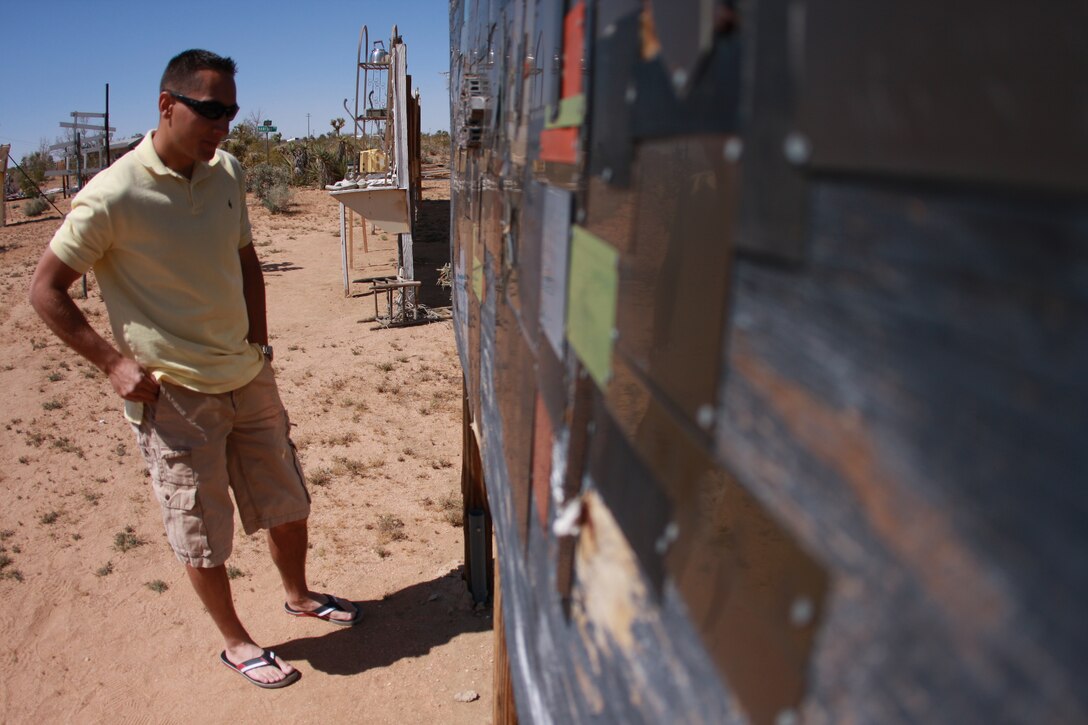 Lance Cpl. Aaron Kristopik, a paralegal clerk with the Combat Center’s Staff Judge Advocate and a native of New Britain, Conn., reads a wall made of plaques with the names of various organizations and deceased service members who’s units are aboard the Combat Center at the Noah Purifoy Outdoor Museum in Joshua Tree, Calif. April 25.