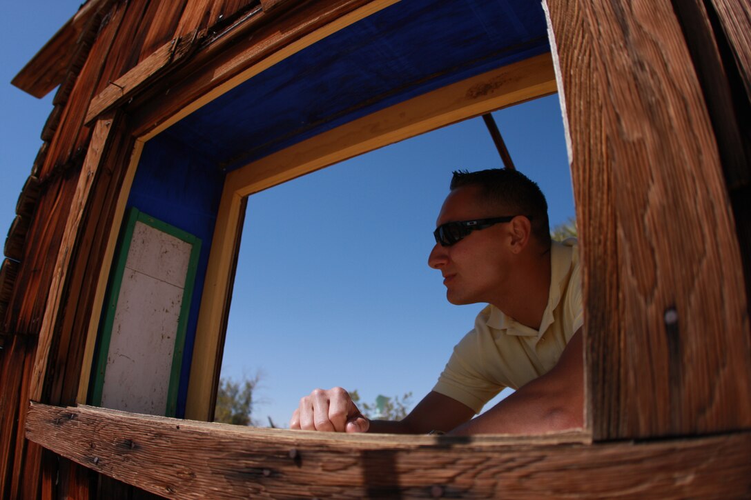 Lance Cpl. Aaron Kristopik, a paralegal clerk with the Combat Center’s Staff Judge Advocate and a native of New Britain, Conn., surveys the rest of the Noah Purifoy Outdoor Museum in Joshua Tree, Calif., through a window in one of the exhibits April 25.