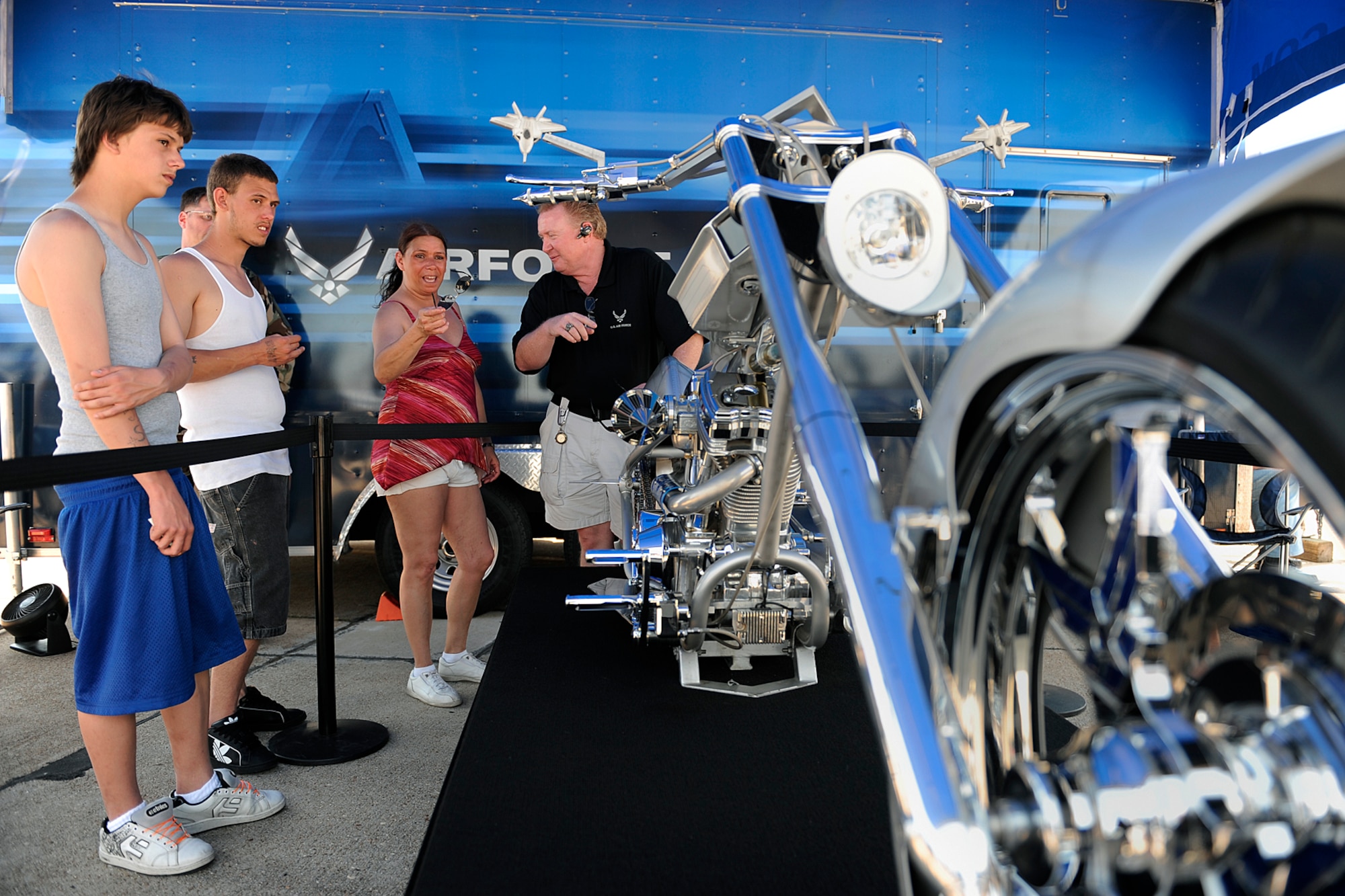LANGLEY AIR FORCE BASE, Va. --  Adrian Taylor, Alex and Robert Flowers, admire the Air Force Orange County Chopper during the Air Power over Hampton Roads here April 25.  Built in 2005, the chopper has a 131 cubic inch engine that generates 150 horsepower. From end to end it stretches 10 feet 3 inches. It features a six-speed Baker right-hand drive that puts power to the 300 series Avon Venom rear tire. The color scheme is based on the F-22 Raptor.  (U.S. Air Force photo/Senior Airman Vernon Young)