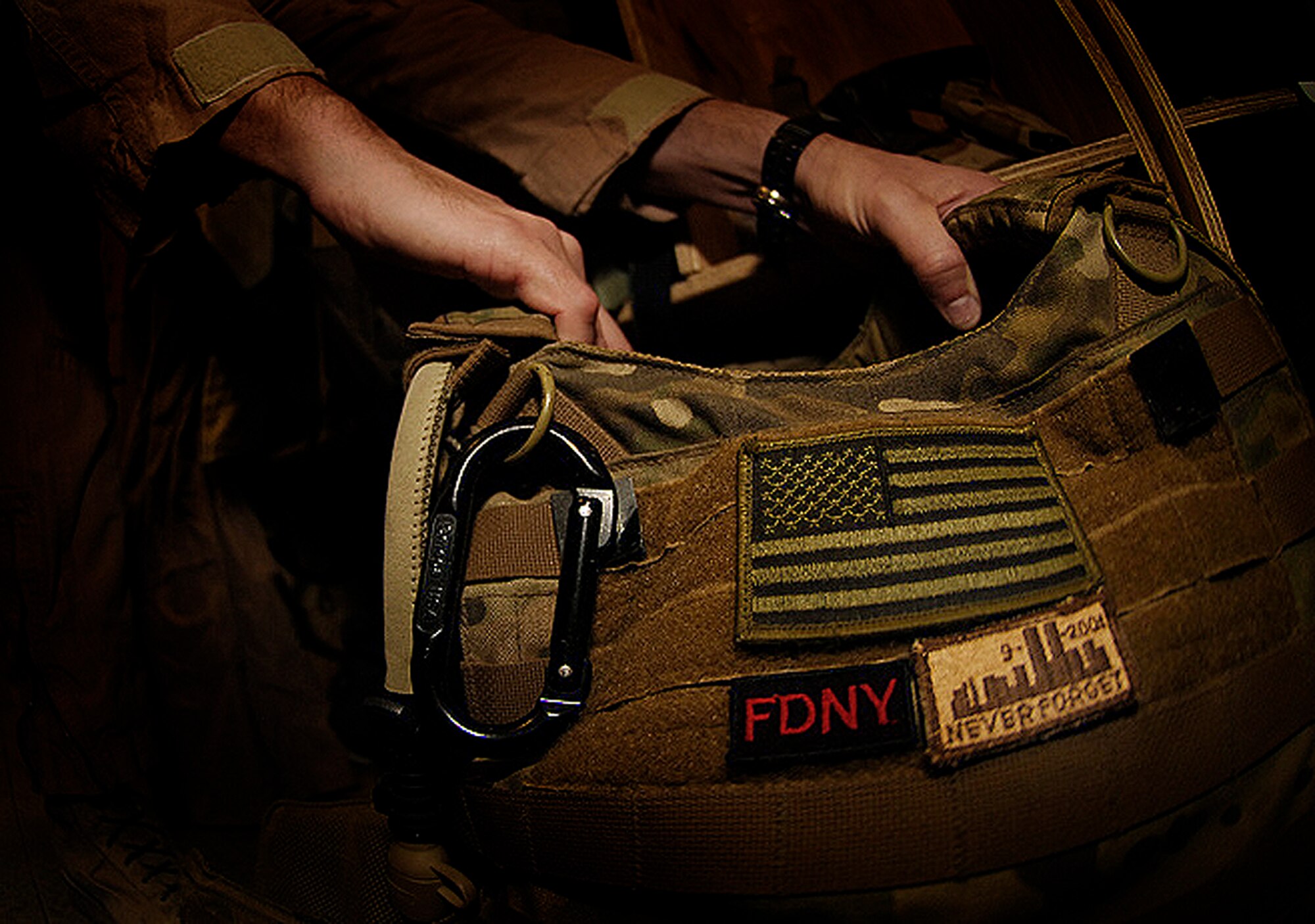 Senior Master Sgt. Glen Berg, 101st Expeditionary Rescue Squadron, gets together his gear before a mission here. Sergeant Berg, a New York Air National Guardsman, is an aerial gunner for the HH-60 Pave Hawk helicopters here and a New York City firefighter back home. Some of the New York Guardsmen in the 101st ERQS wear patches like this 9-11 patch as a reminder while they stand on alert to rescue downed pilots and ground troops wounded behind enemy lines. New York's 101st Rescue Squadron from West Hampton Beach, N.Y., is preparing to head home after supporting Operation Enduring Freedom for nearly five months. (Air Force/Staff Sgt. Jason Lake)