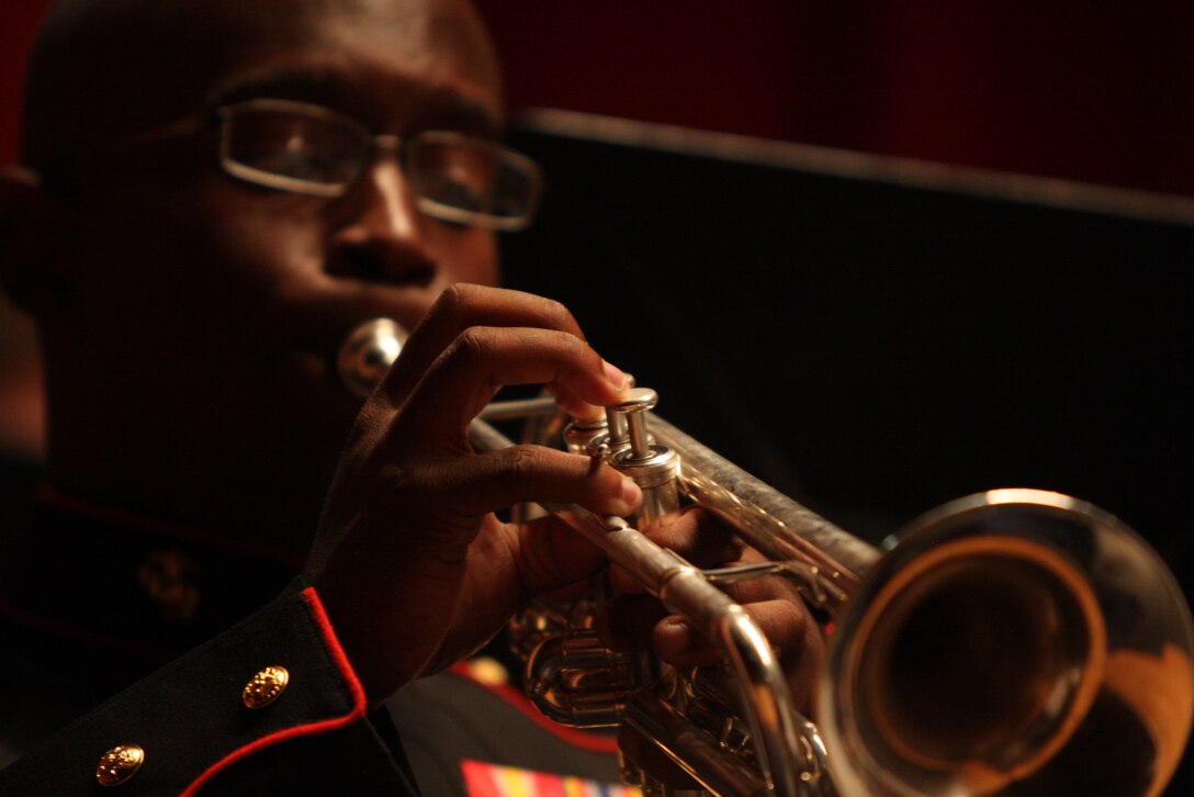 Lance Cpl. Daniel Phillips, a trumpeter with the Combat Center band makes his trumpet sing during the Coats of Red and Blue 2 concert at the Sunset Cinema Sunday.