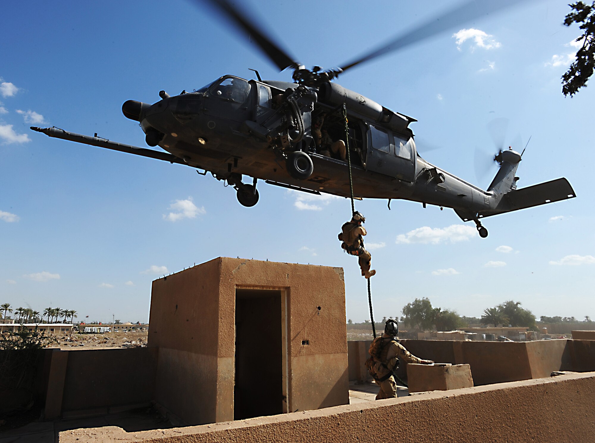 A pararescueman fast ropes from an HH-60 Pave Hawk helicopter to join a team member in a proficiency exercise outside of Baghdad, Iraq. They are assigned to the 64th Expeditionary Rescue Squadron at Joint Base Balad, Iraq.  (U.S. Air Force photo/Staff Sgt. James L. Harper Jr.) 