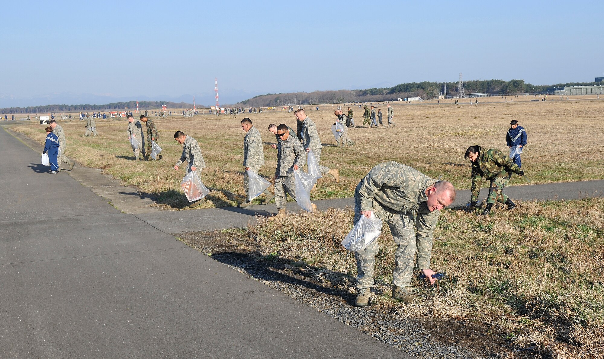 MISAWA AIR BASE, Japan -- Misawa Airmen pick up foreign objects on the airfield during the annual fighter wing foreign object damage walk April 17, 2009. This annual FOD walk focuses primarily on the runway, infield and the taxiway.  (U.S. Air Force photo by Senior Airman Chad C. Strohmeyer)